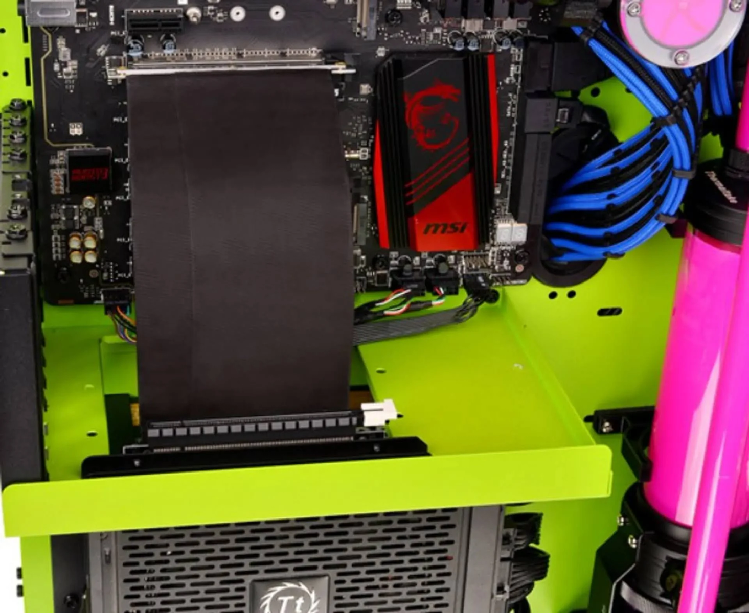 Case PC con scheda madre, cavo nero, elementi verdi e neri e tubi rosa.