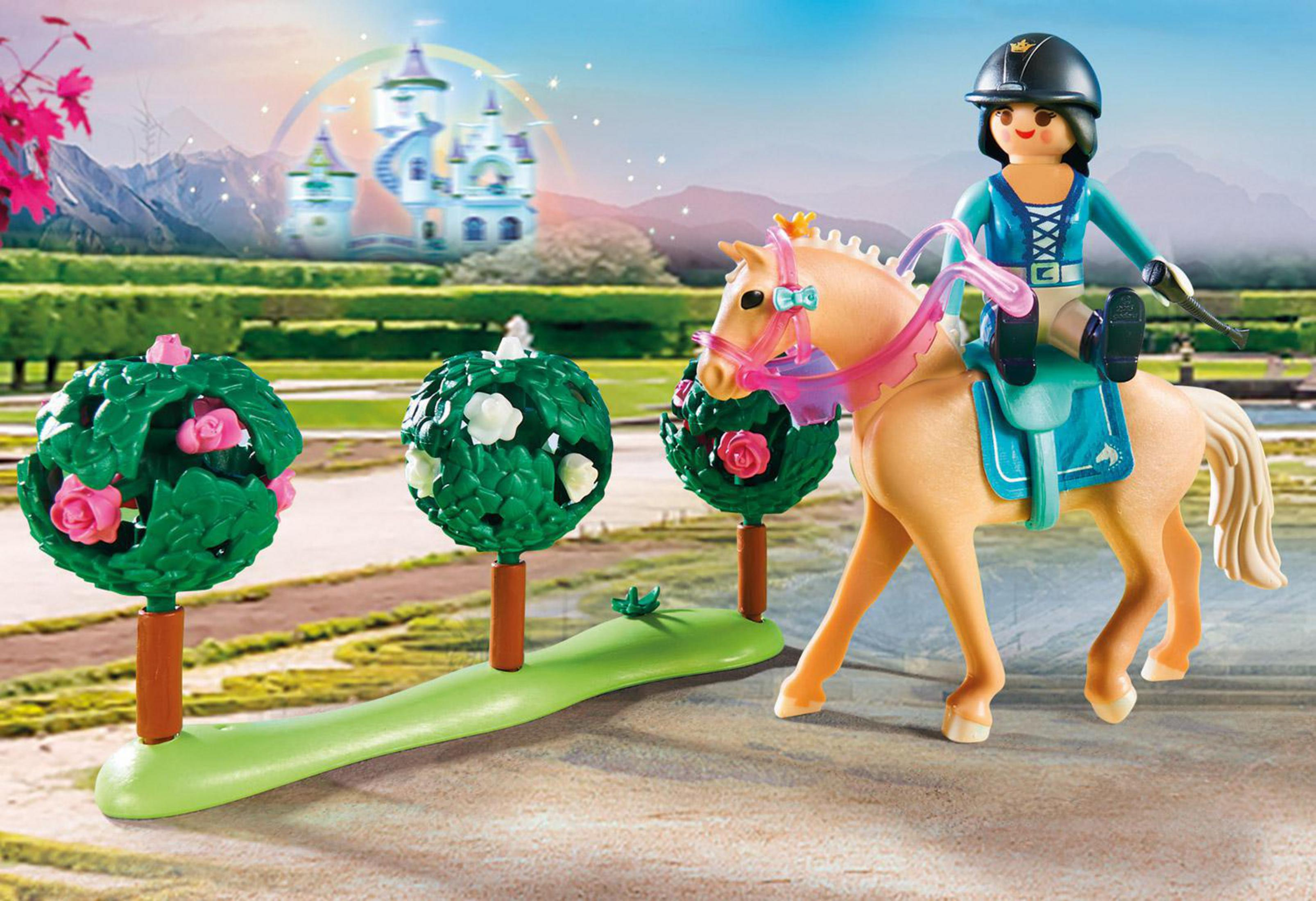 Scena Playmobil z księżniczką na koniu w ogrodzie, zamek w tle.