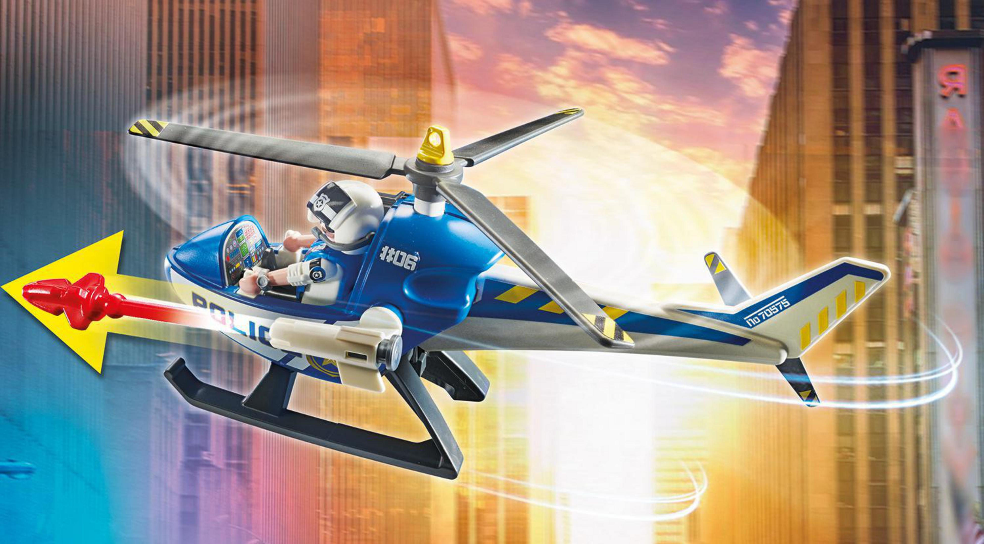 Helicóptero de policía de juguete azul y blanco. Aspas del rotor, un piloto y copiloto, y ciudad de fondo.