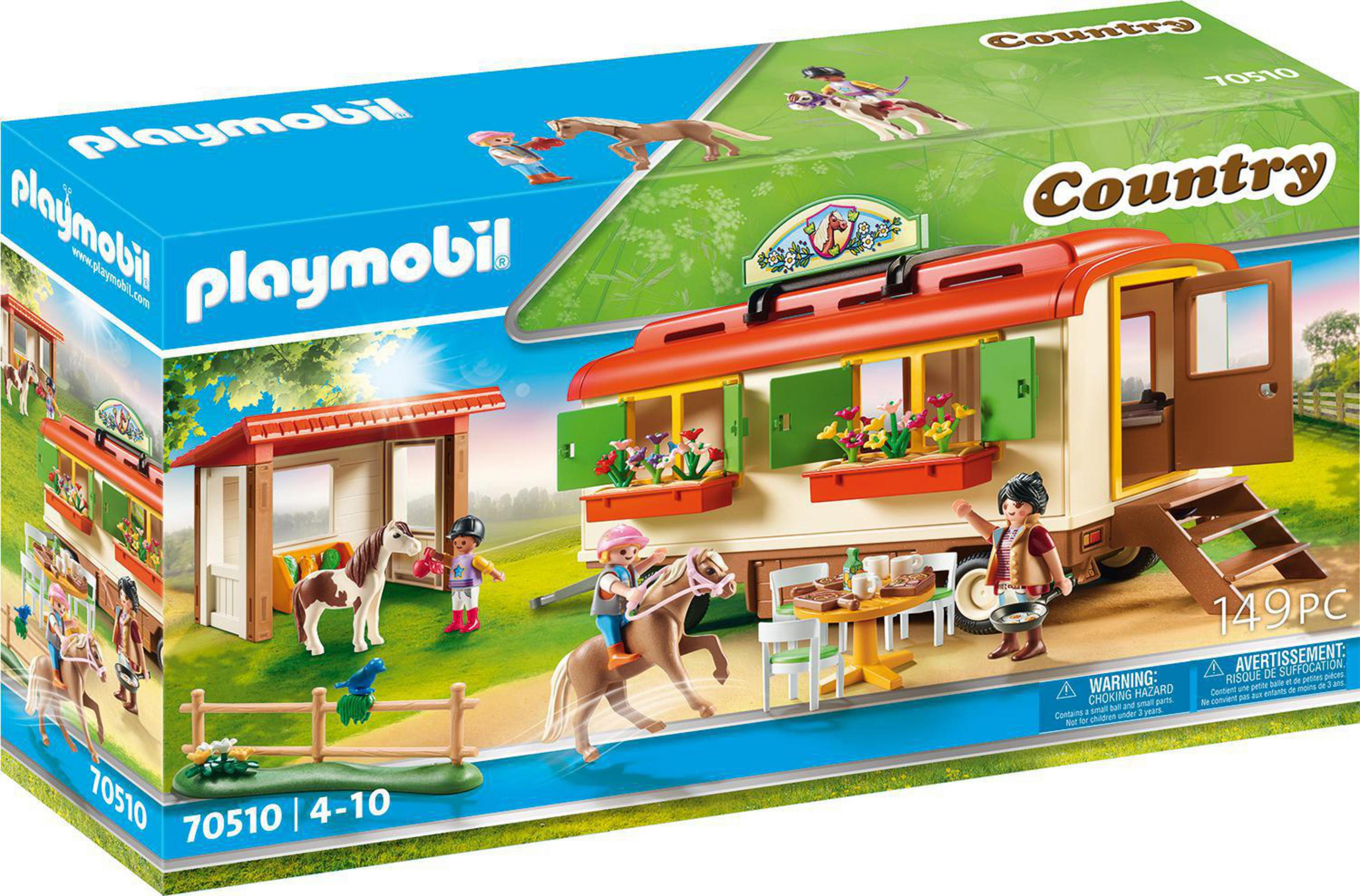 Un set scatola Playmobil con rimorchio, cavallo e personaggi. Una ragazza cavalca un cavallo e un'altra figura sta cucinando.