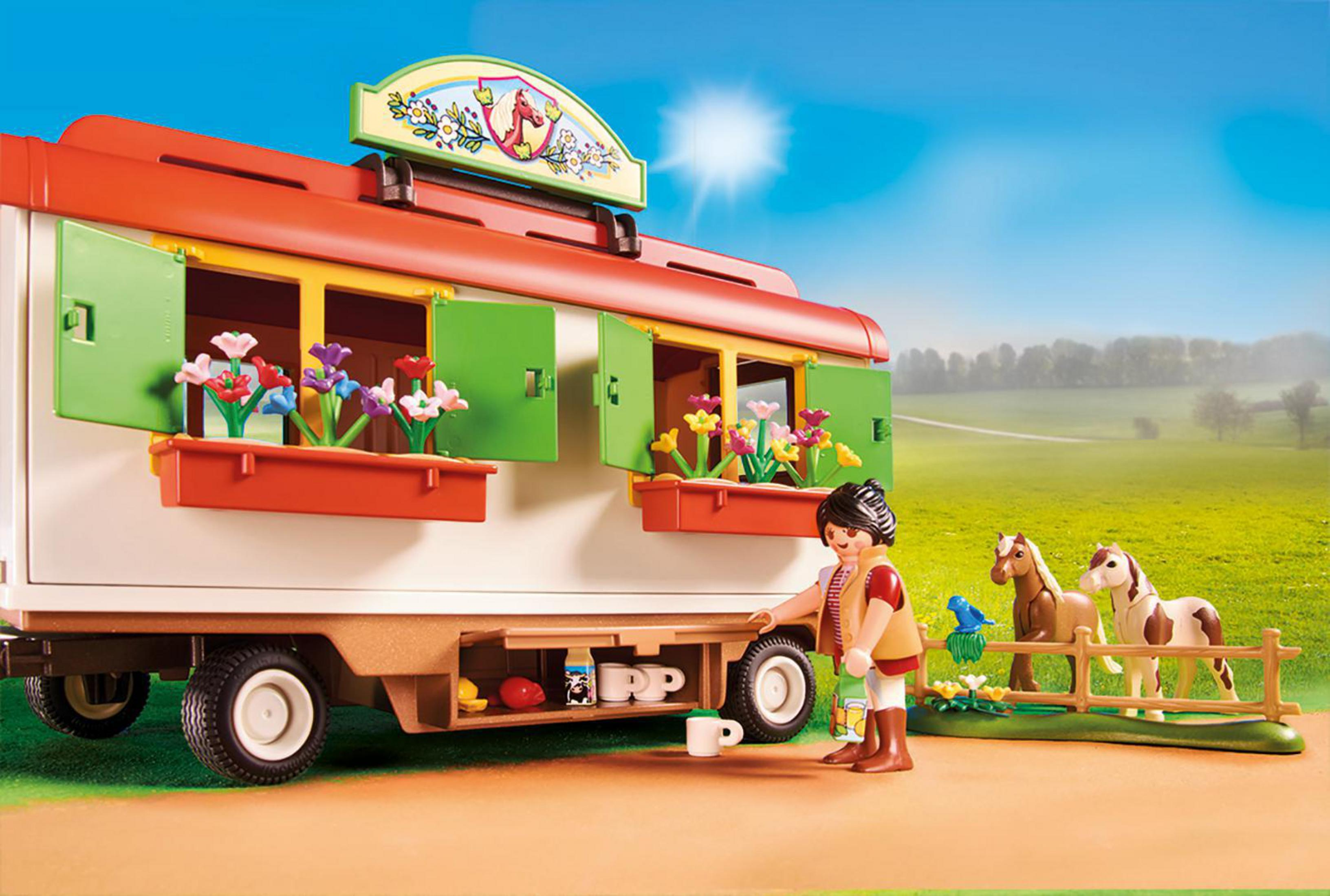 Una scena di giocattoli Playmobil di un carro trainato da cavalli con una persona, cavalli e tazze. La scena è ambientata all'aperto.