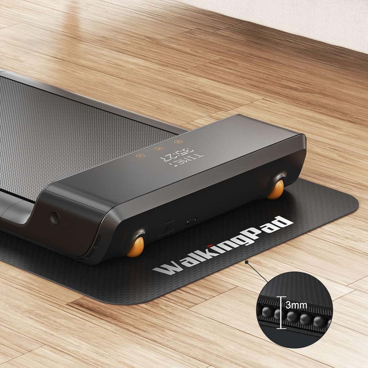 Tapis roulant nero su pavimento in legno, con display digitale. Logo WalkingPad bianco sul tappetino.