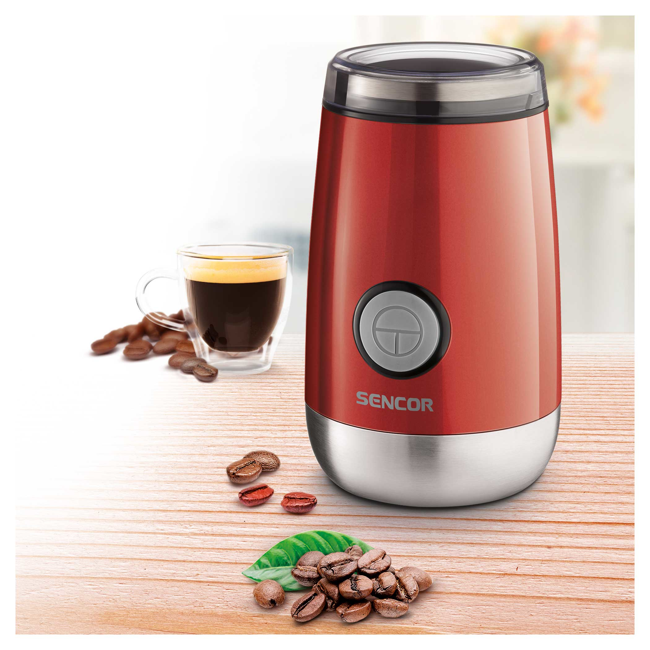 Ein roter SENCOR Kaffeemühle, Kaffeebohnen und eine Tasse Kaffee auf einer Holzoberfläche.