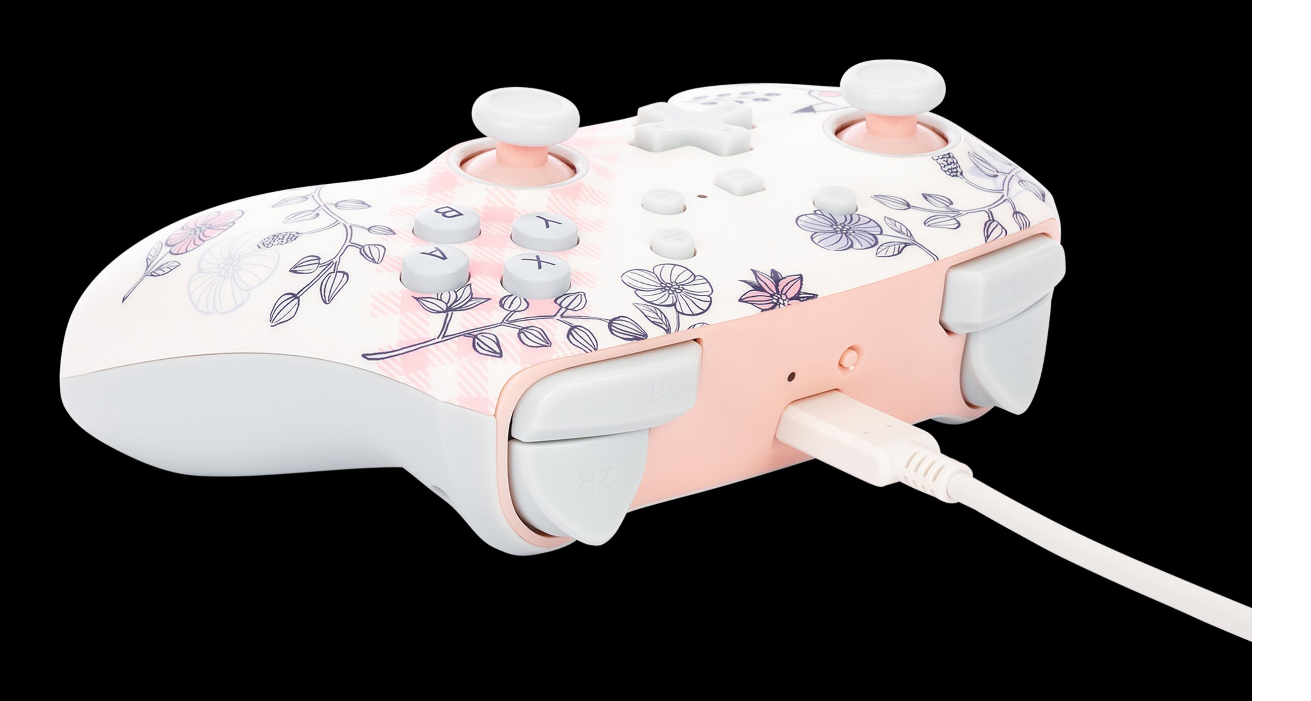 Różowy i biały kontroler do gier z kwiatowym wzorem i kablem USB.