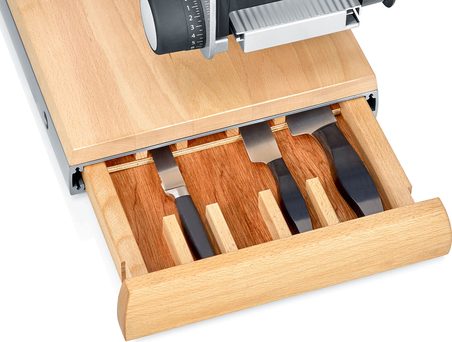 Gros plan d'une planche à découper en bois avec des couteaux dans un tiroir. Les couteaux sont dans une fente.
