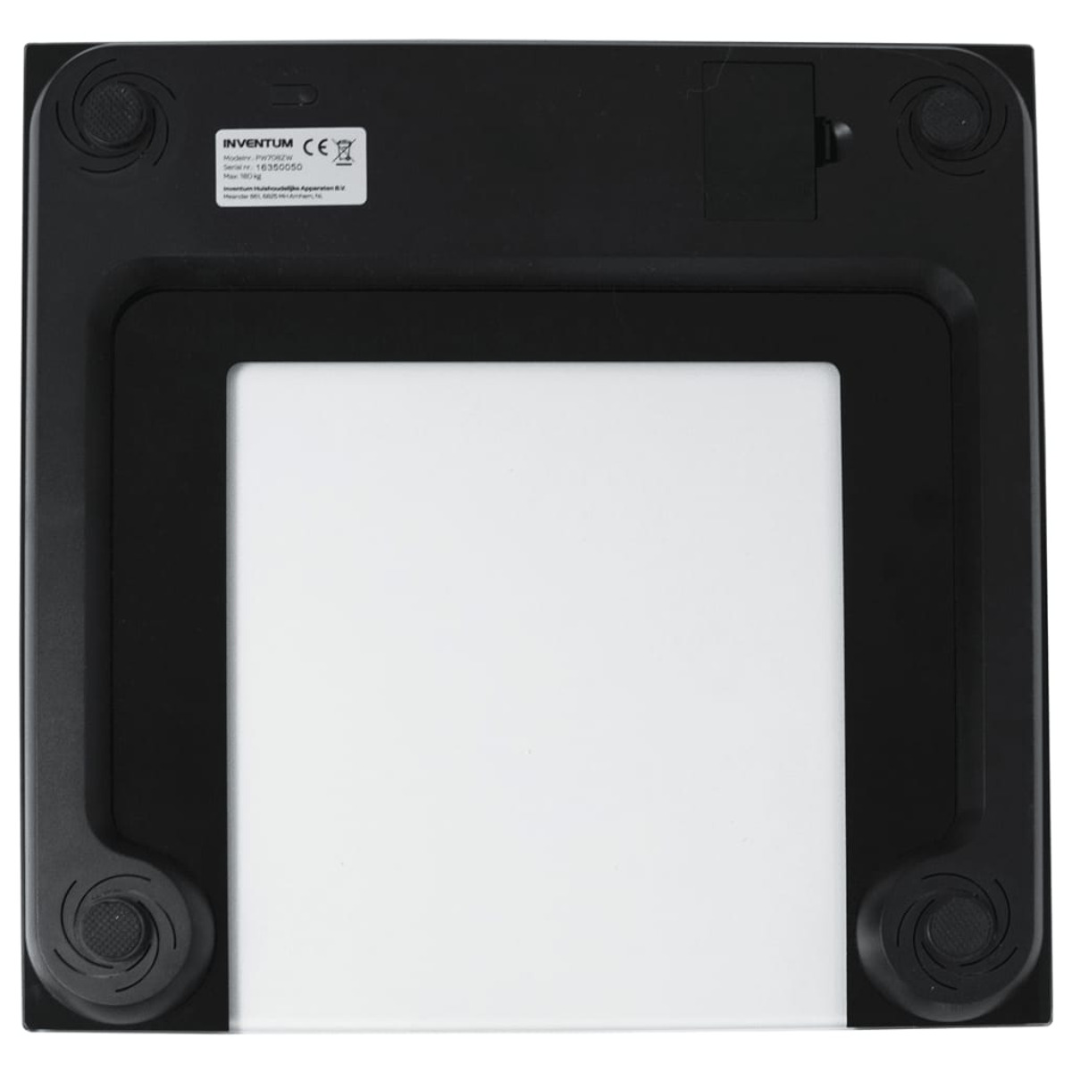 Il lato inferiore di una bilancia digitale da bagno. È nero, con vetro bianco al centro e quattro piedi.