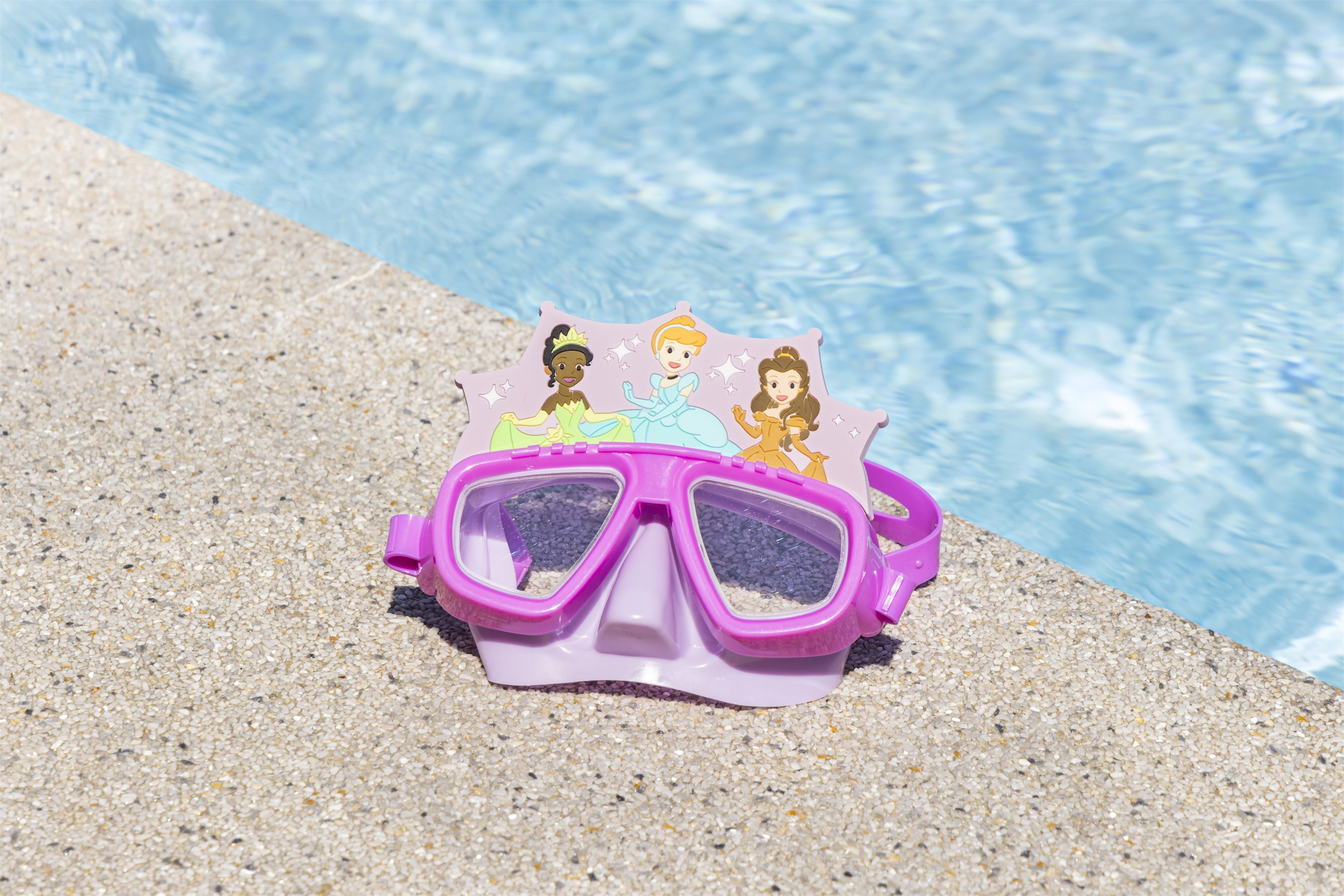 Occhialini da nuoto rosa con corona da principessa e principesse, a bordo piscina.