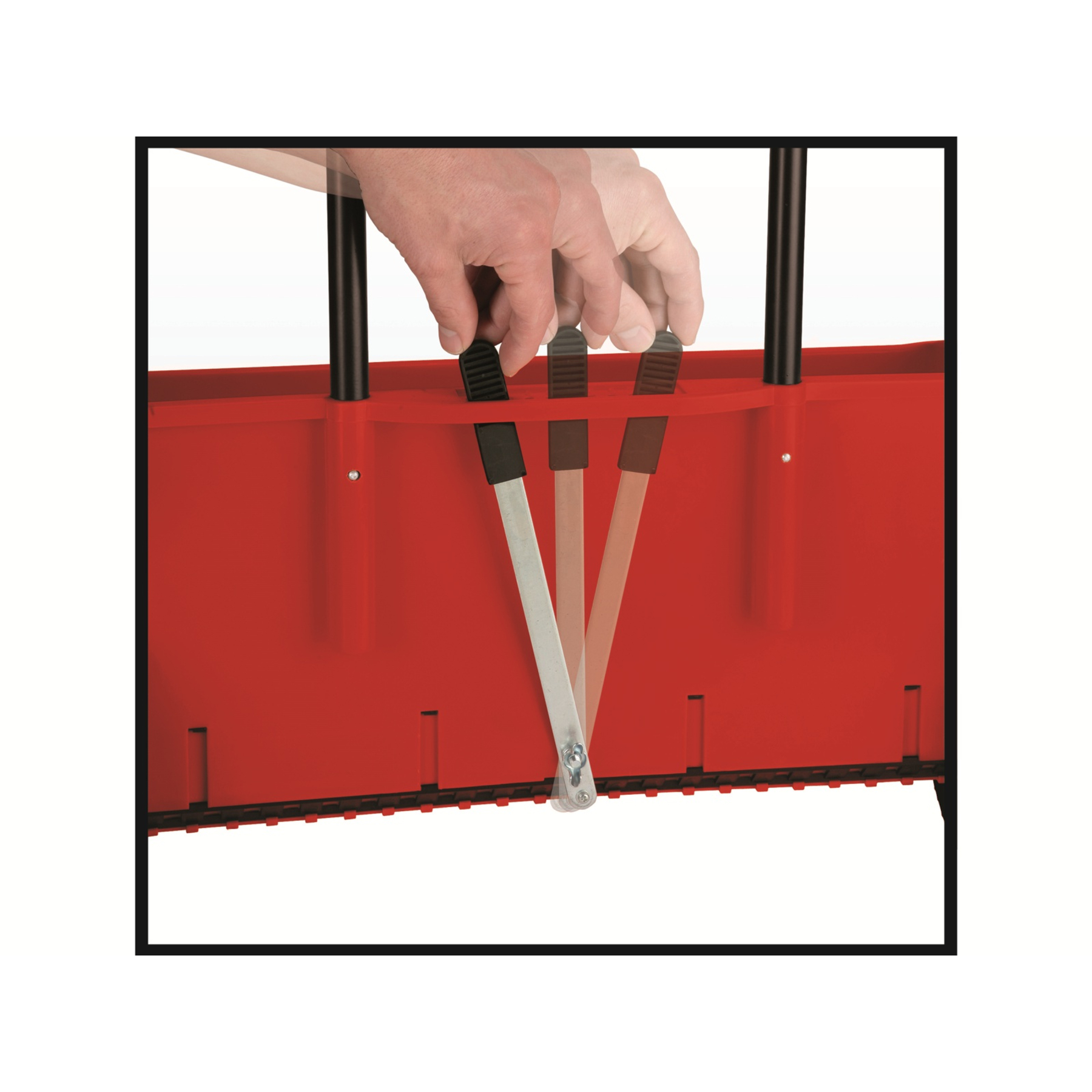 Ręce osoby regulującej czerwone i czarne dźwignie na czerwonym obiekcie.