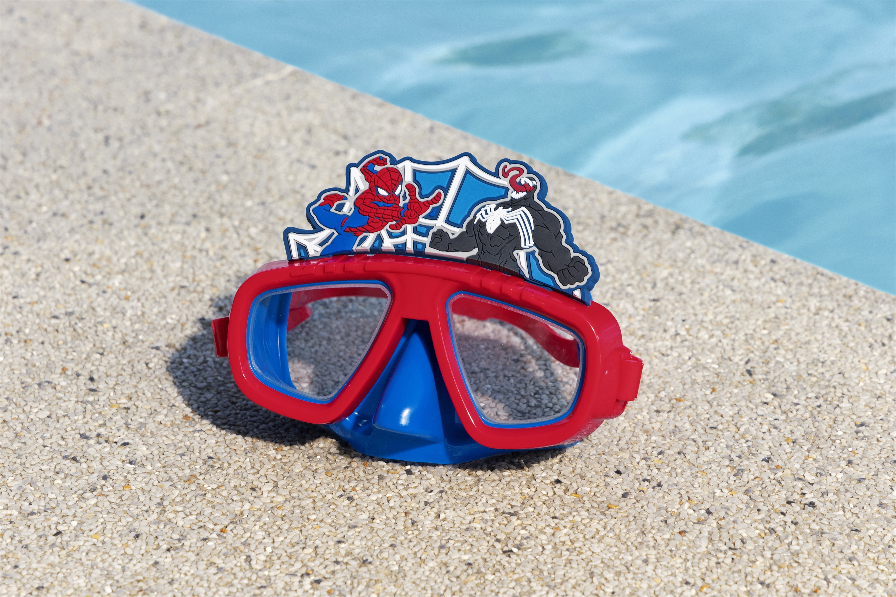 Occhialini rossi e blu con decorazioni di Spider-Man e Venom vicino a una piscina.