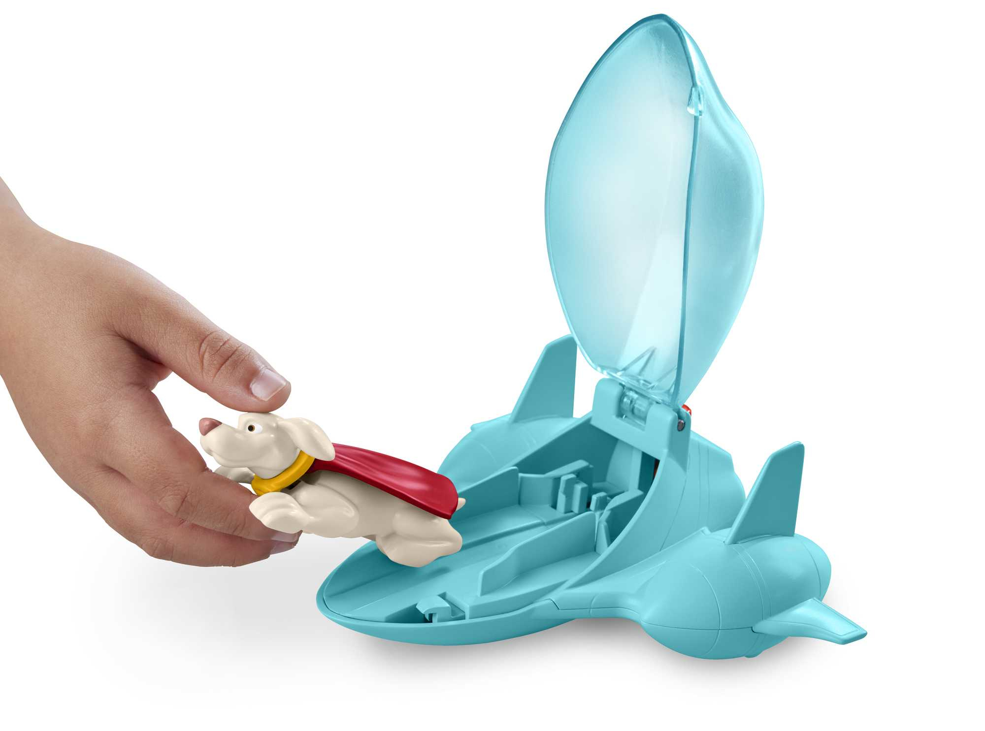 Ręka dziecka trzymająca białą zabawkę psa z czerwoną peleryną. Zabawka jest w niebieskim statku kosmicznym.