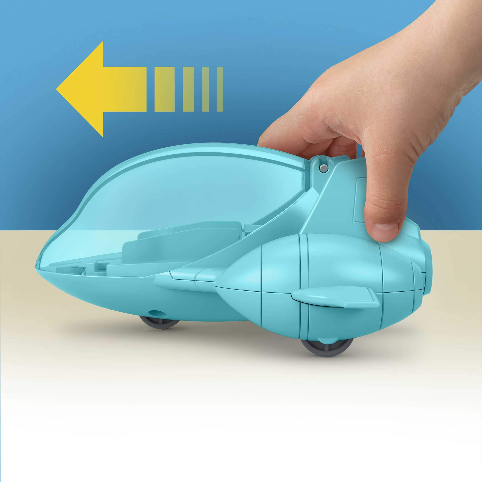 Ręka trzymająca niebieski pojazd-zabawkę z przezroczystym dachem. Żółta strzałka wskazuje kierunek ruchu.