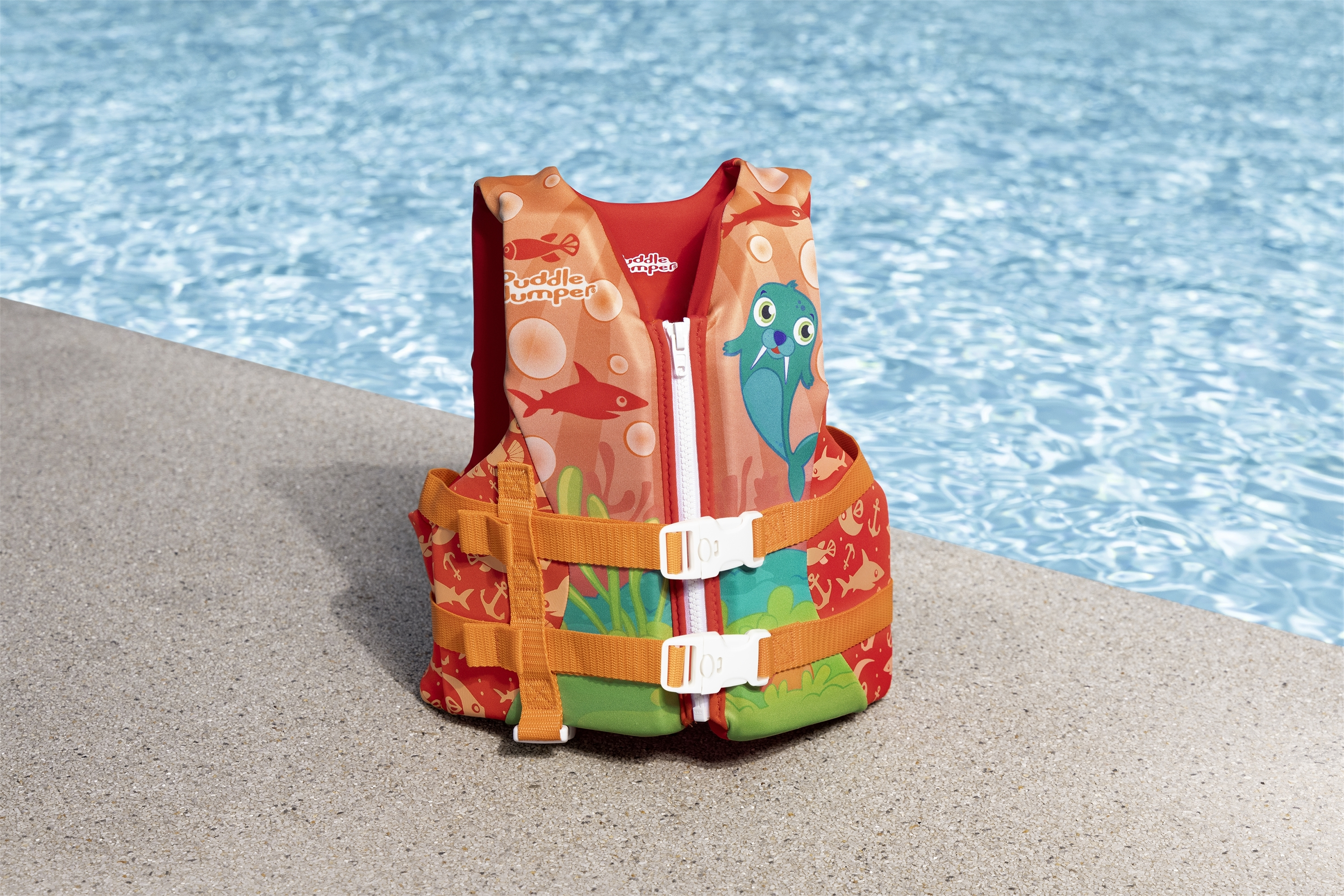 Gilet di salvataggio in piscina. Il gilet è rosso con pesci e un disegno di pesce blu.