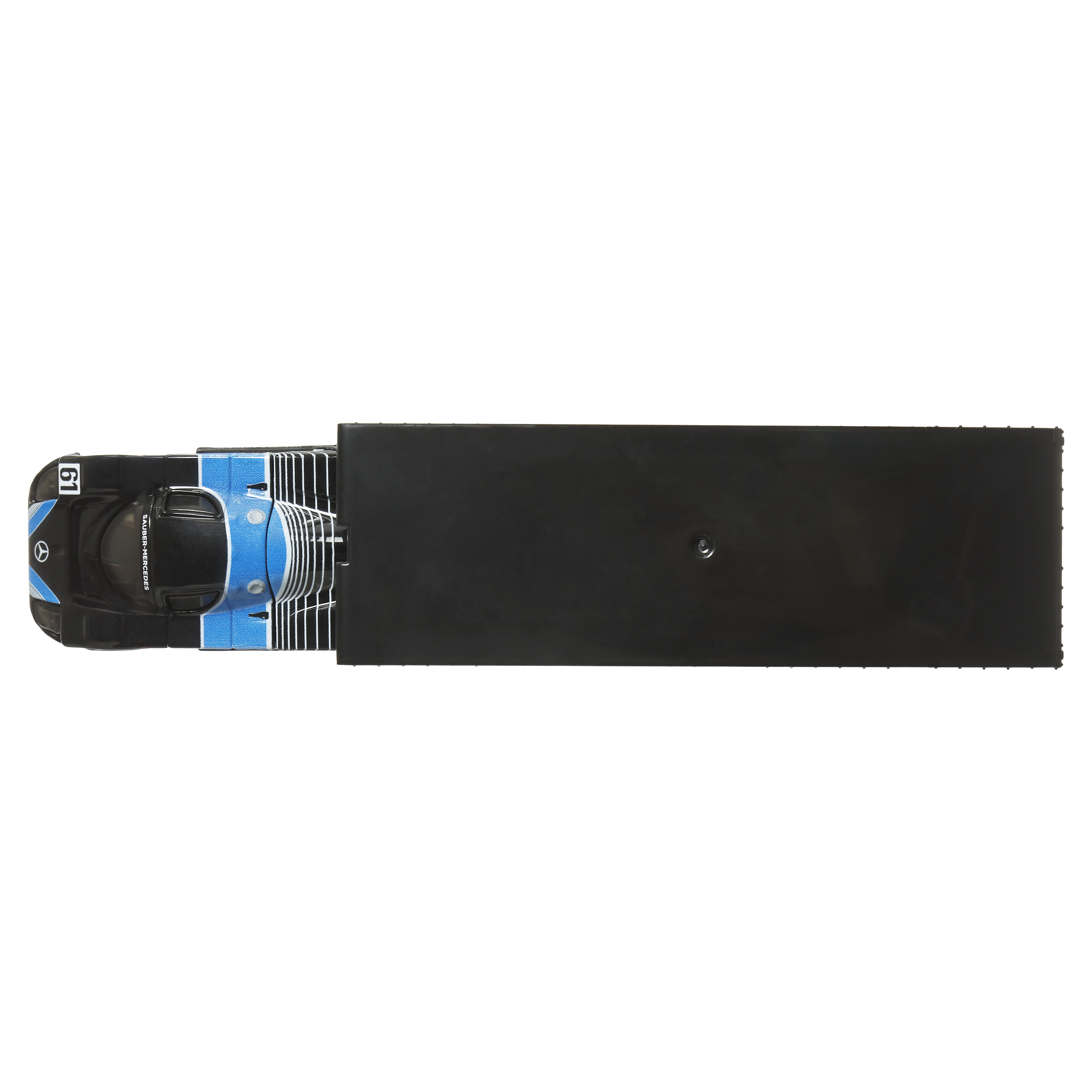 Ein schwarz-blaues Spielzeug-Rennauto in einer schwarzen Box, Draufsicht.