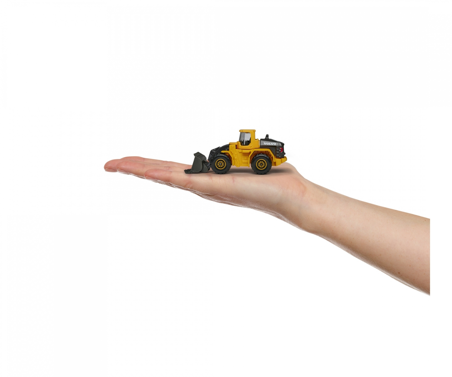 Ręka trzymająca żółtą zabawkę ładowarki czołowej Volvo. Maszyna jest żółta i czarna.