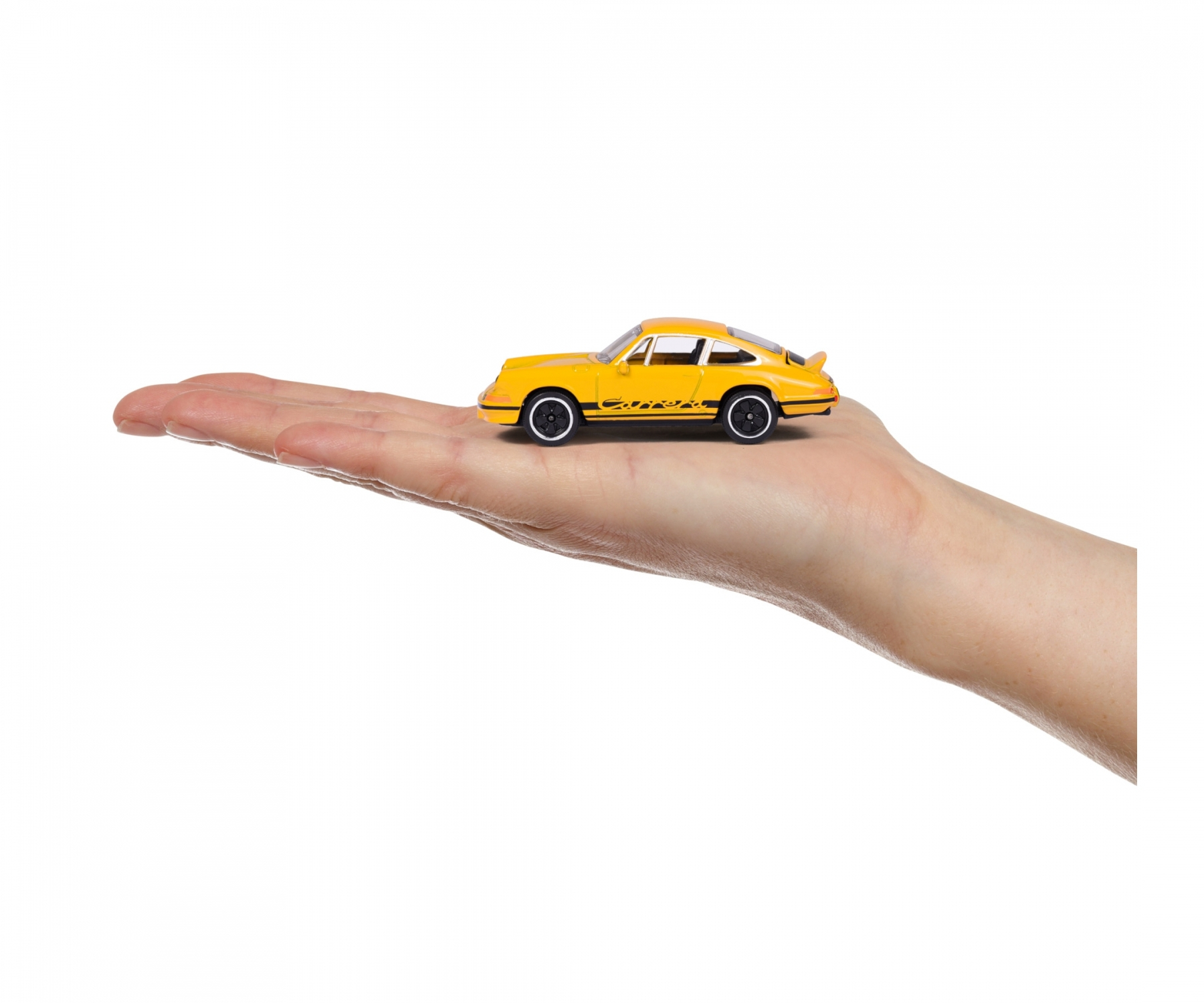 Żółty zabawkowy samochód Porsche trzymany na dłoni, na białym tle.