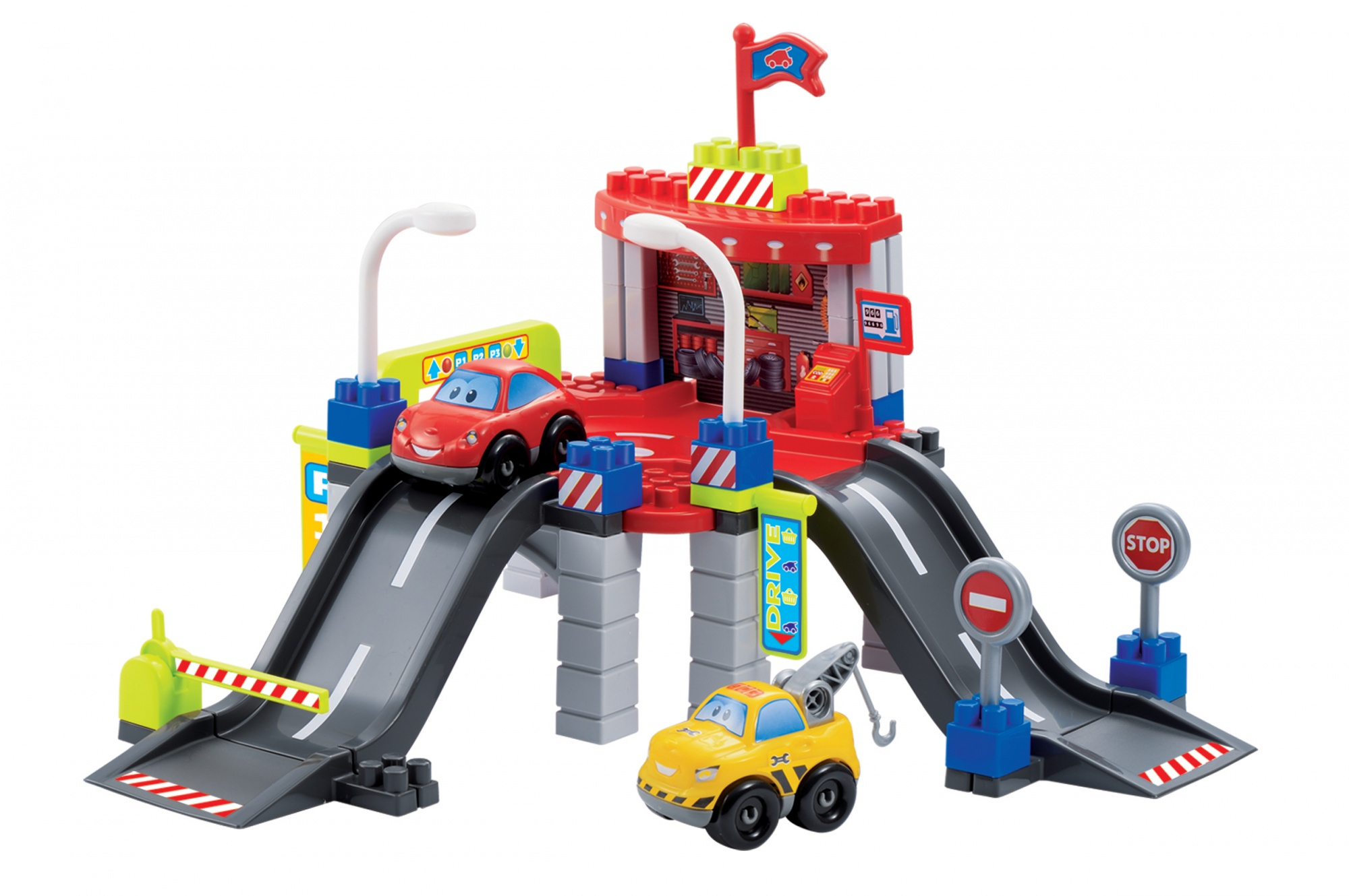 Zabawkowy garaż z rampami, samochodami i znakami. Obecny jest żółty holownik i czerwony samochód.
