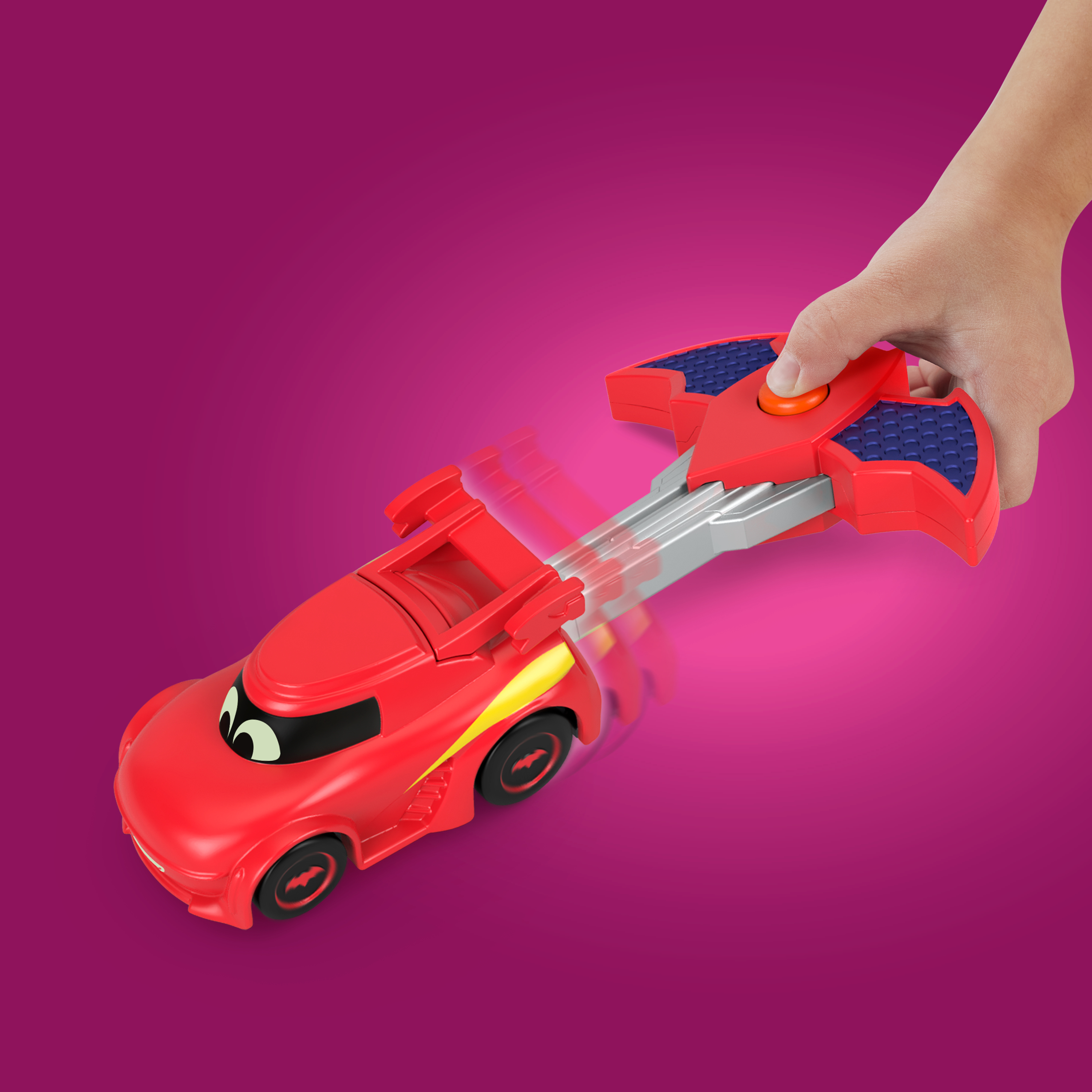 Czerwony samochodzik z żółtym paskiem jest sterowany przez czerwonego pilota na różowym tle.