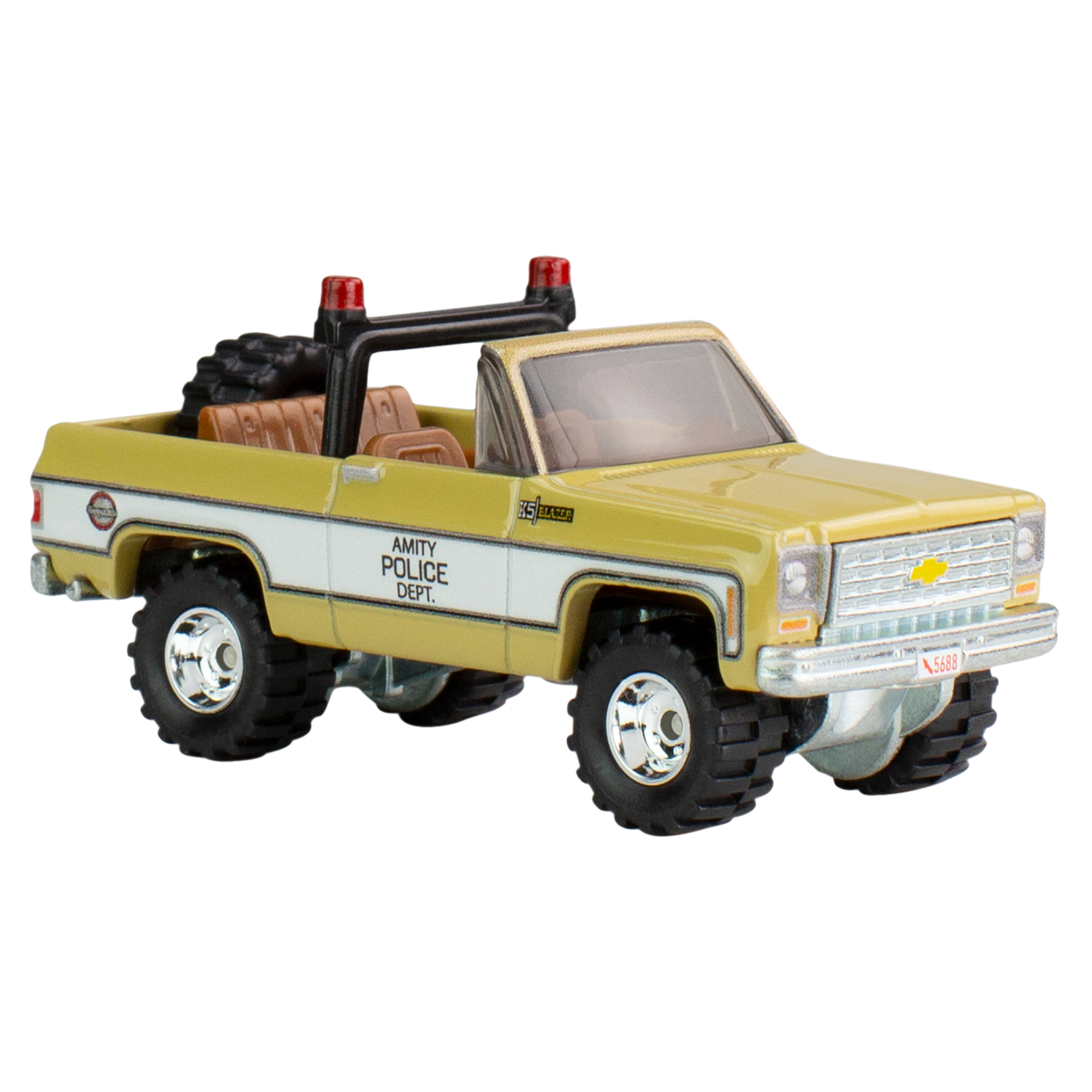 Żółto-biała zabawka ciężarówka z napisem 'Amity Police Dept.'. Ma czerwone światła.