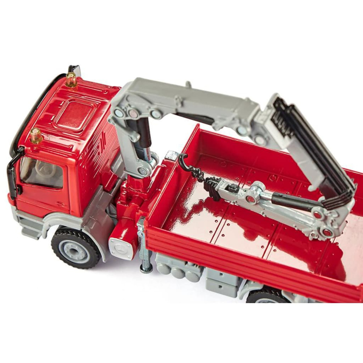 Czerwona zabawka ciężarówka z szarym żurawiem na białym tle. Żuraw jest wysunięty.