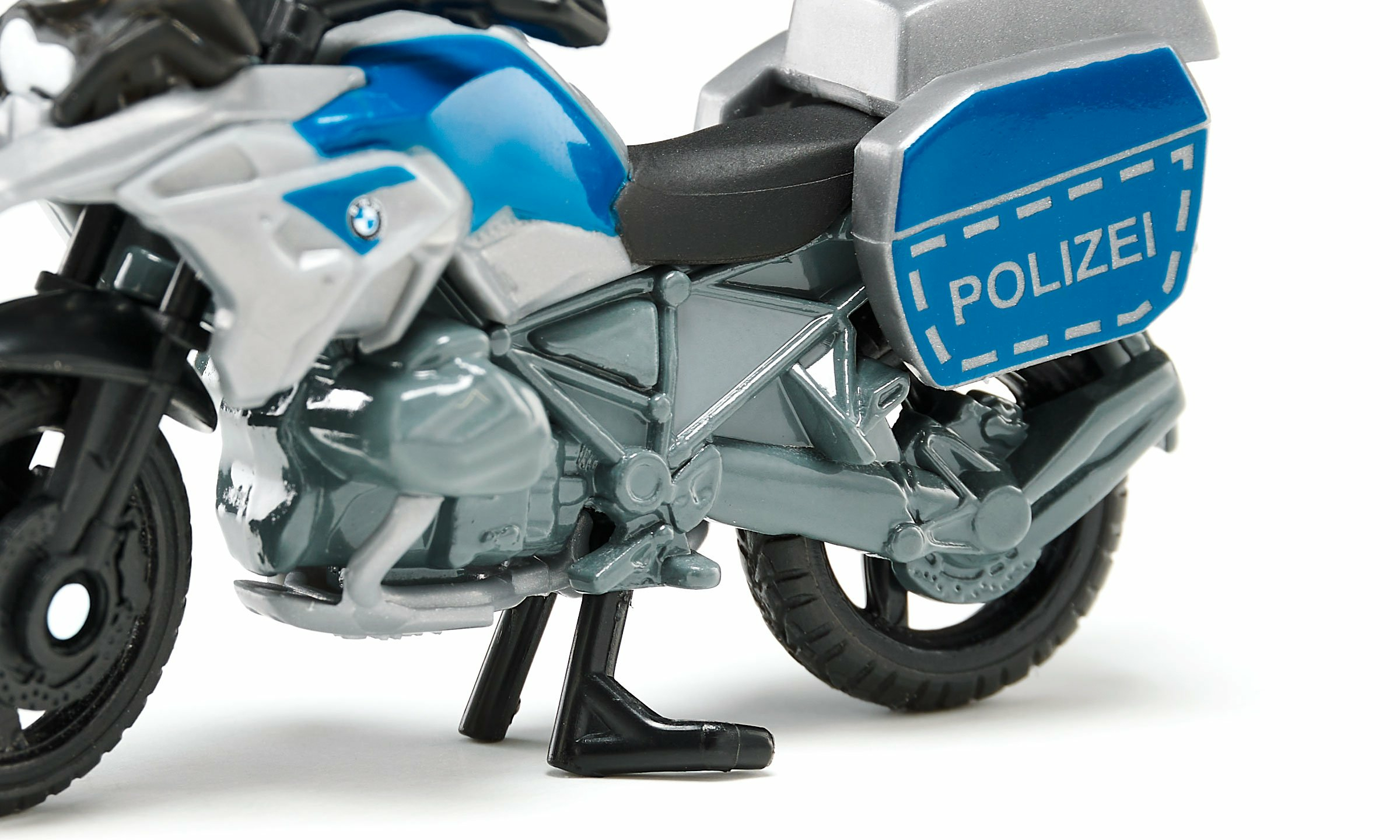 Primo piano di una moto della polizia giocattolo. Colori bianco, blu e grigio. Etichetta POLIZEI.