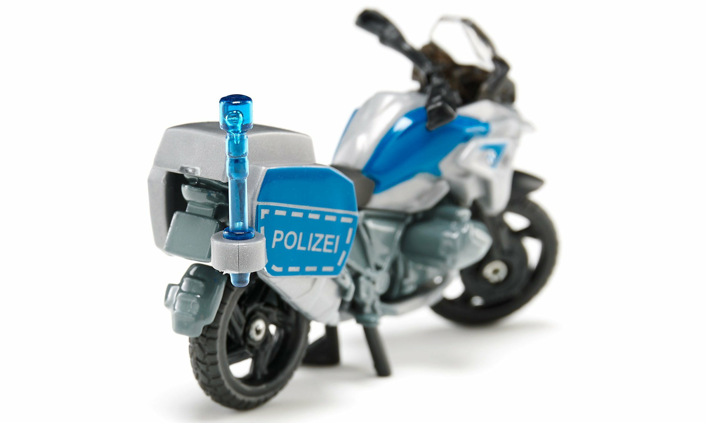 Motocicletta della polizia giocattolo. Colori bianco, blu e grigio. Etichetta POLIZEI sul lato.