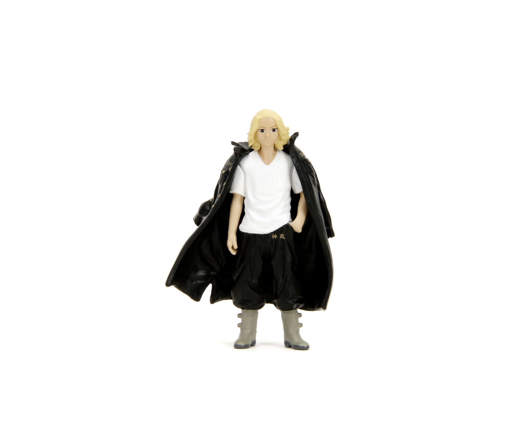 Mała figurka osoby z blond włosami i czarnym płaszczem, stojącej na białej powierzchni.