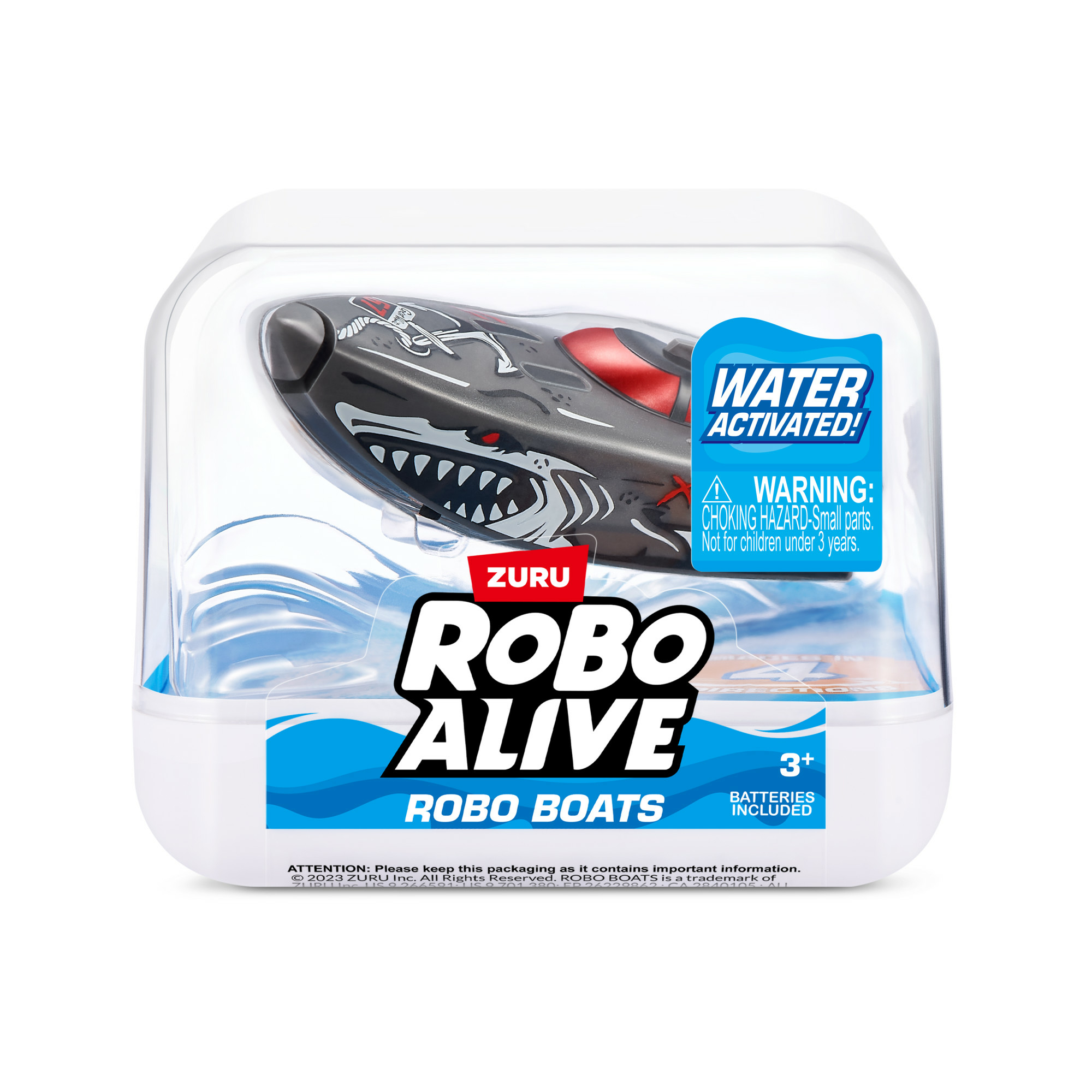 Zabawkowa rekin w przezroczystym pojemniku. Rekin jest szary z czerwonym akcentem. Opakowanie zawiera tekst.