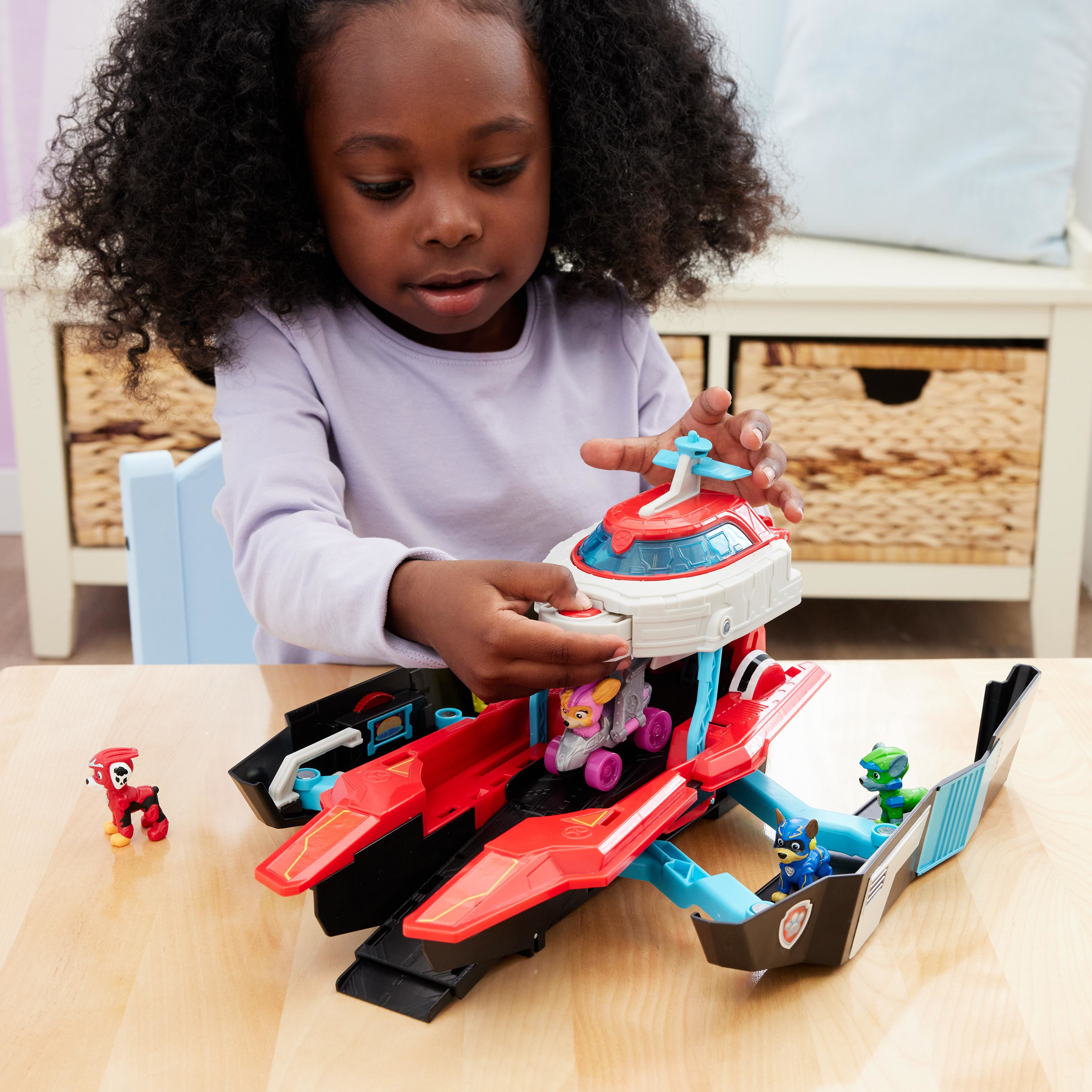 Dziewczynka bawi się zestawem zabawek Paw Patrol. Zabawka jest czerwona z Skye, Chasem i czerwoną zabawką potwora.