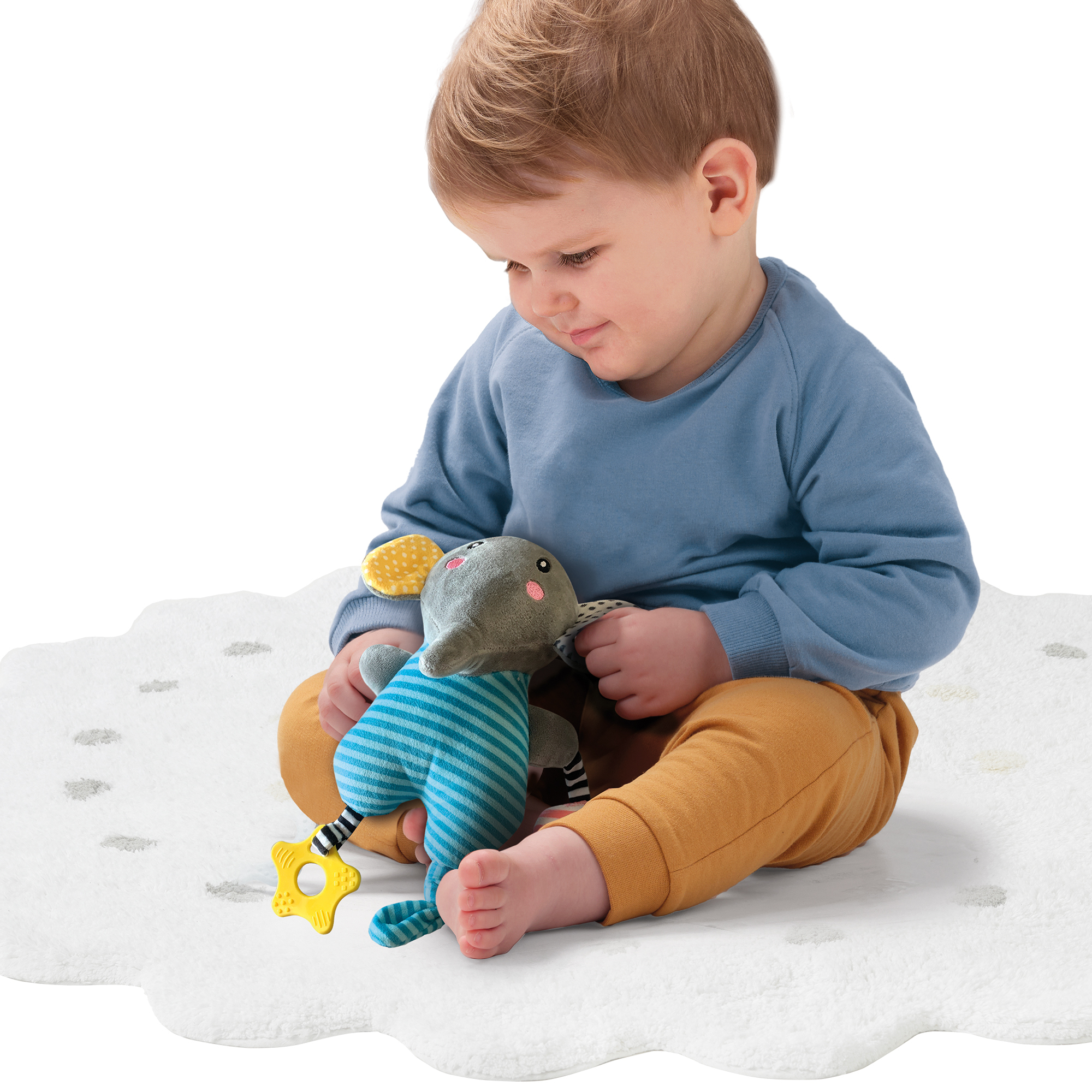Ein Baby sitzt auf einer weißen wolkenförmigen Matte und spielt mit einem Elefanten-Spielzeug. Der Hintergrund ist weiß.
