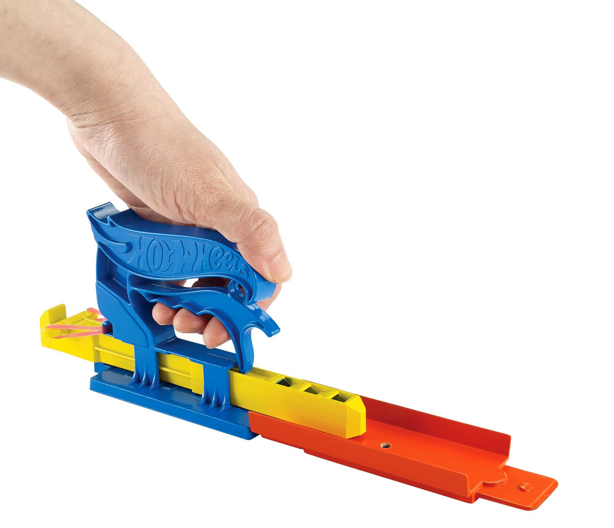 Dłoń trzymająca niebiesko-żółtą wyrzutnię toru Hot Wheels. Tor jest pomarańczowy i żółty.