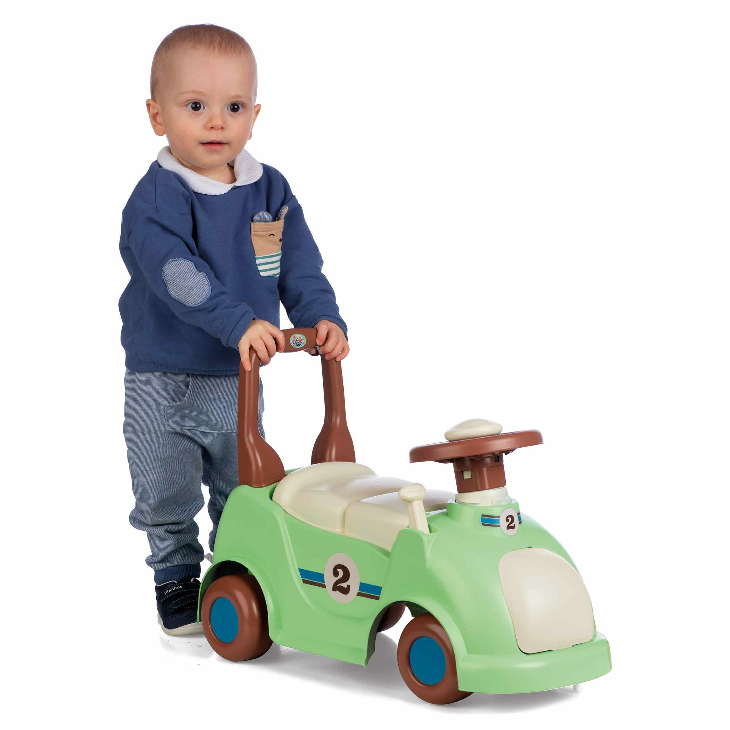 Bambino con un'auto giocattolo verde. Camicia e pantaloni blu. Sfondo bianco.