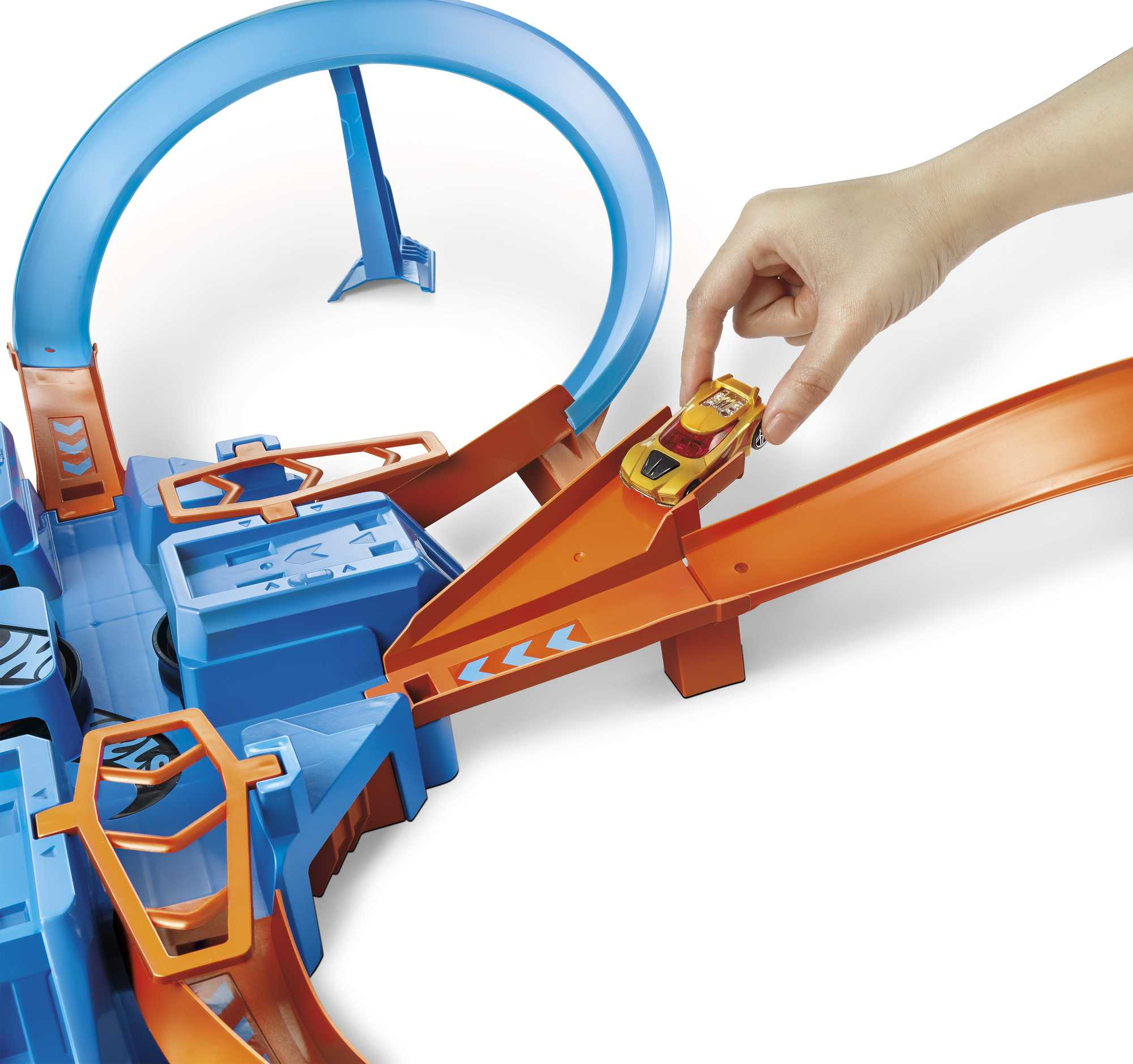 Hand platziert gelbes Spielzeugauto auf einem orangefarbenen Streckenabschnitt. Blaue Basis mit Schleife im Hintergrund.