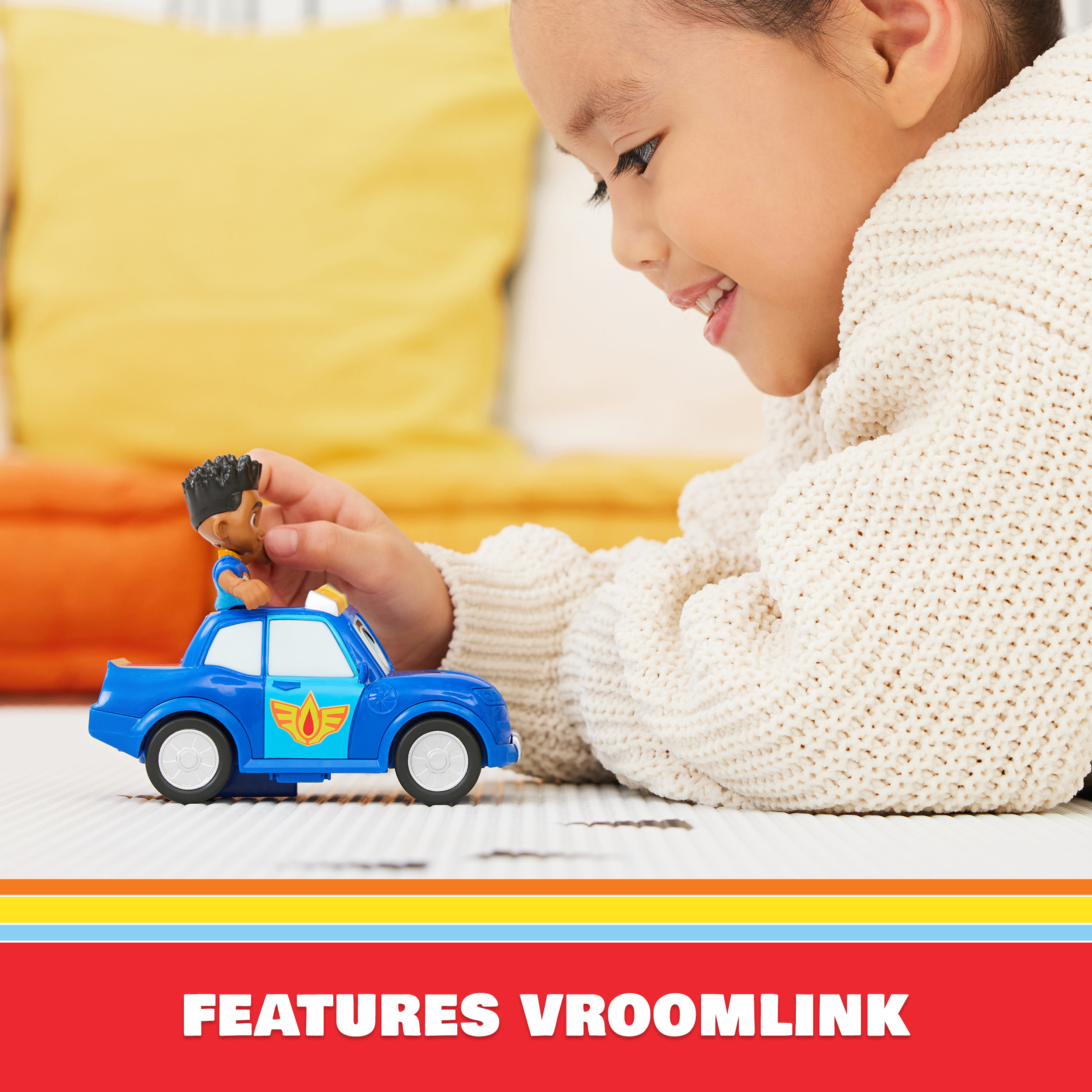 Dziecko bawi się niebieskim radiowozem. Zabawka ma kierowcę. Tekst: 'features vroomlink'.
