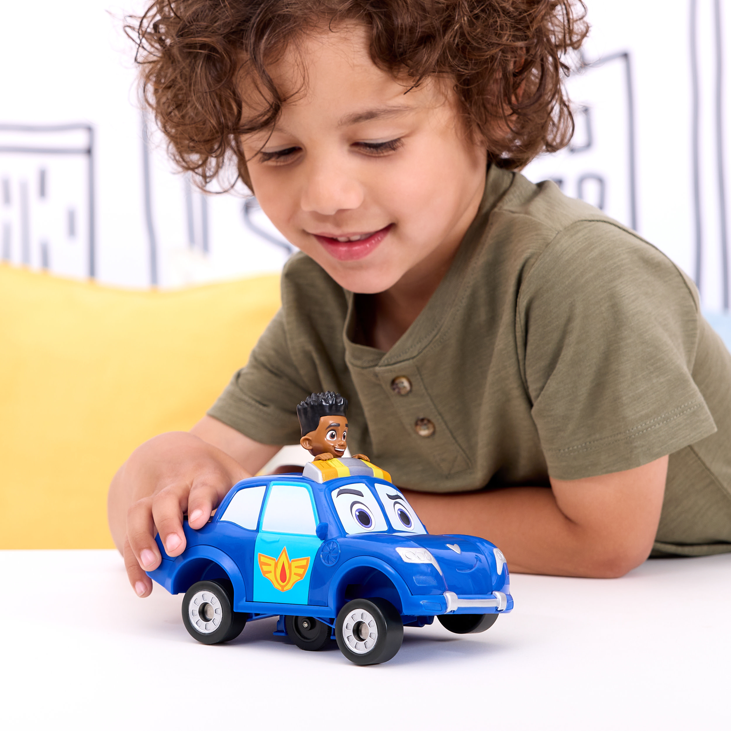 Mały chłopiec bawi się niebieskim samochodzikiem policyjnym. Na górze znajduje się czarnoskóry ludzik.