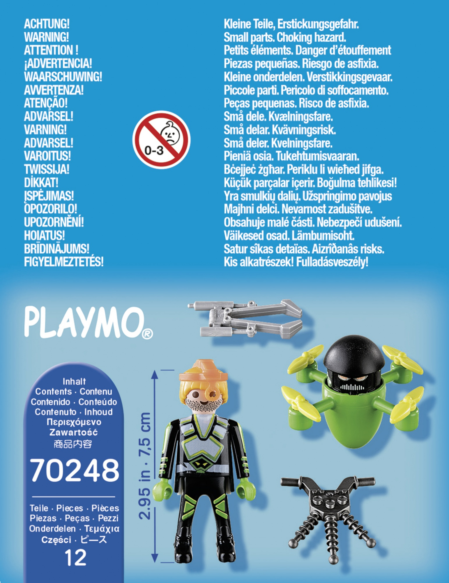 L'immagine mostra il contenuto della scatola Playmobil, tra cui un personaggio, un drone e accessori. L'immagine include anche un avvertimento.