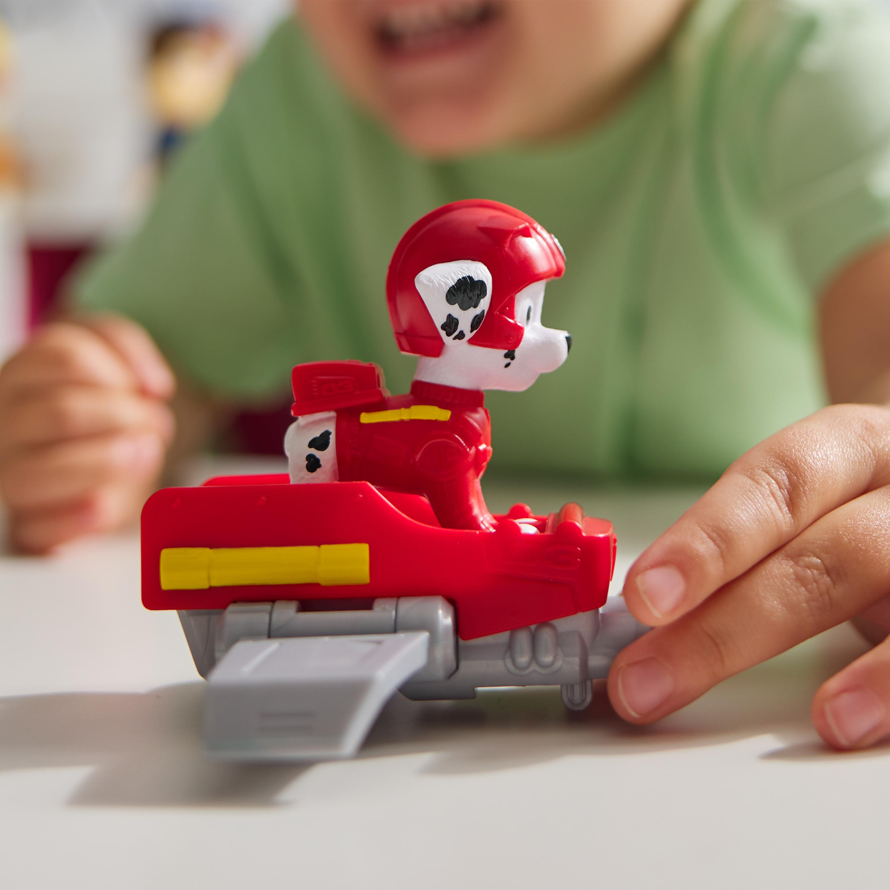 Eine Spielfigur eines Hundes in einem roten Düsenflugzeug wird gezeigt. Der Hund trägt einen Helm.