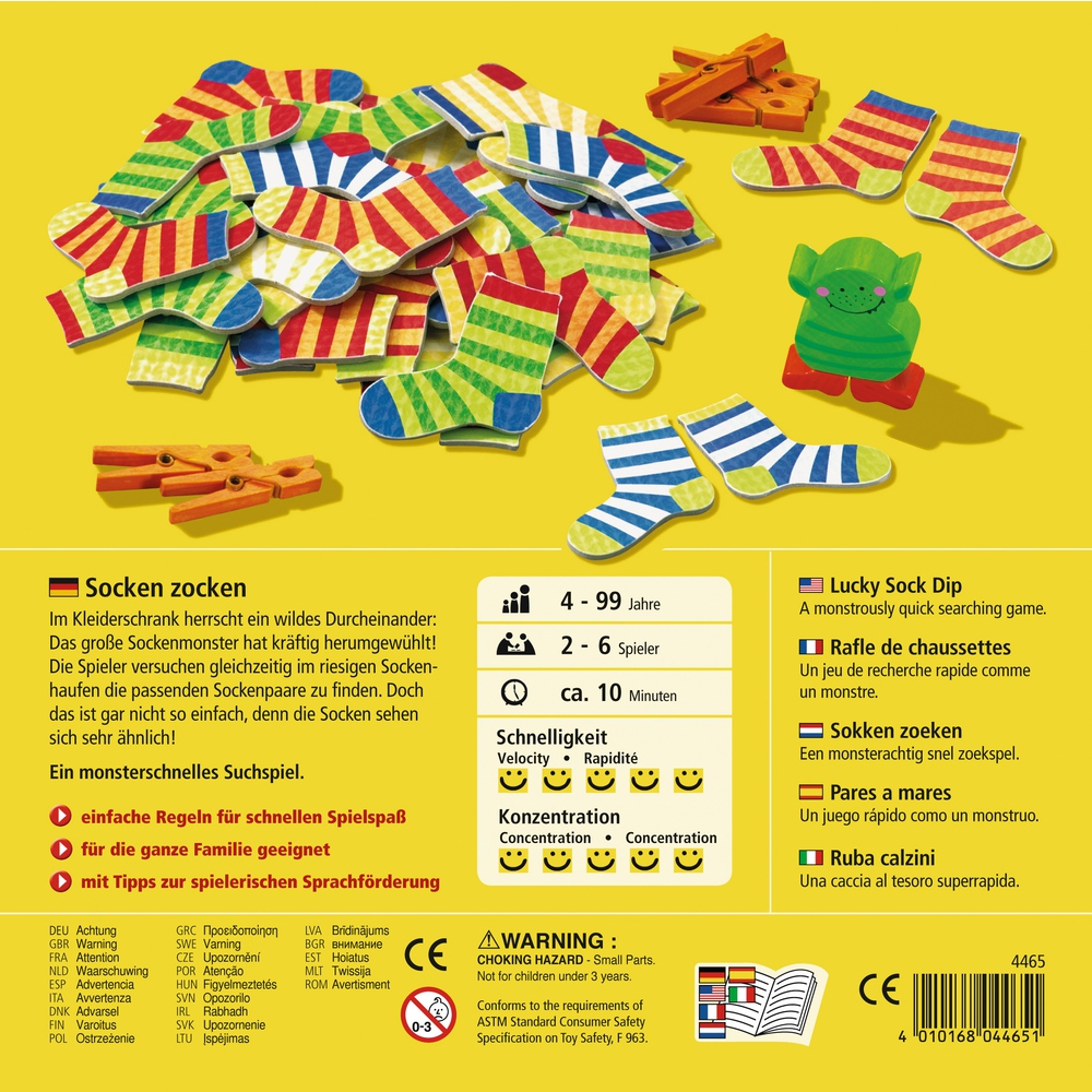 Ein Brettspielkasten mit bunten Socken und einer grünen Monsterfigur auf blauem Hintergrund.