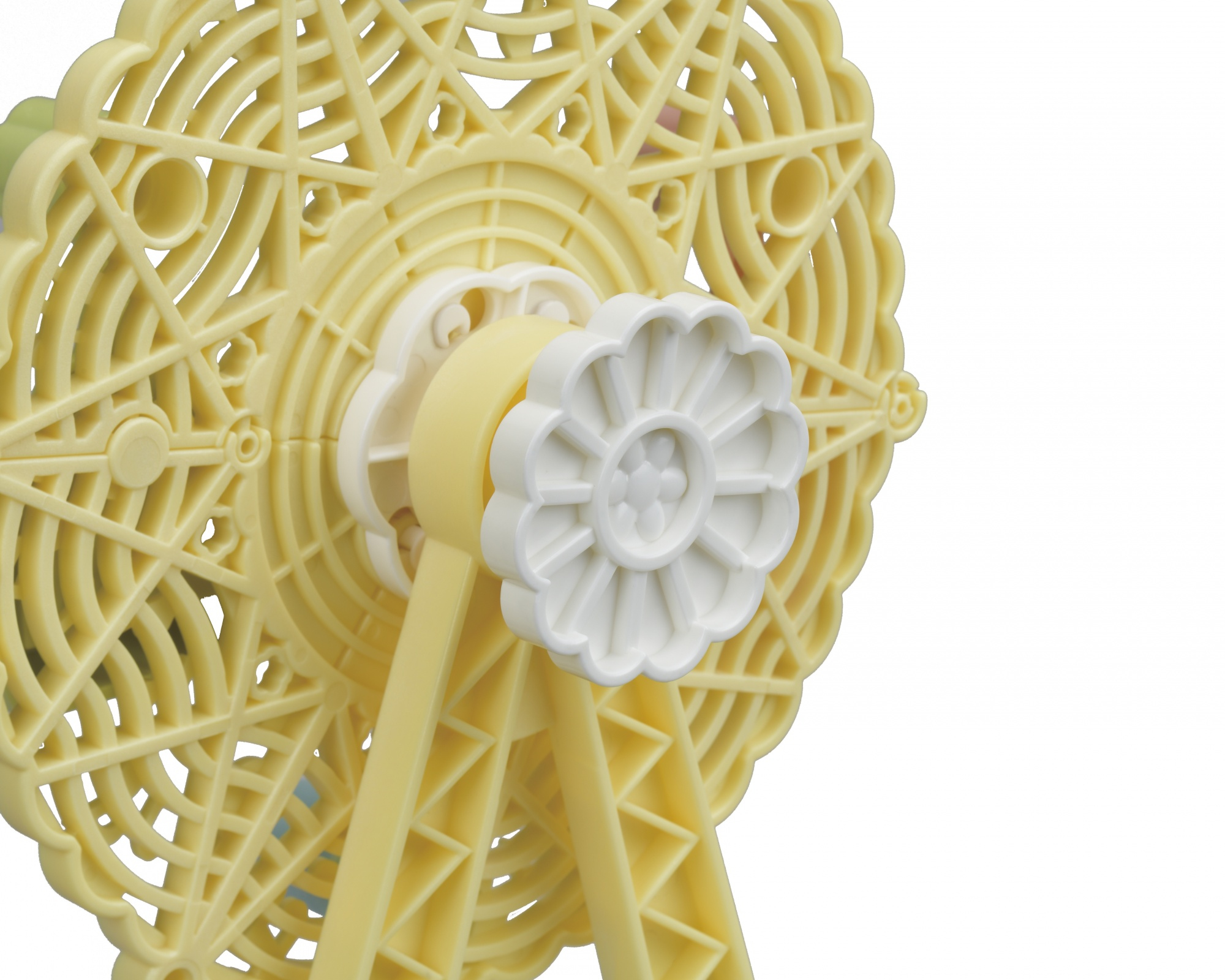 Żółta zabawka w kształcie diabelskiego młyna. Jest na białym tle.