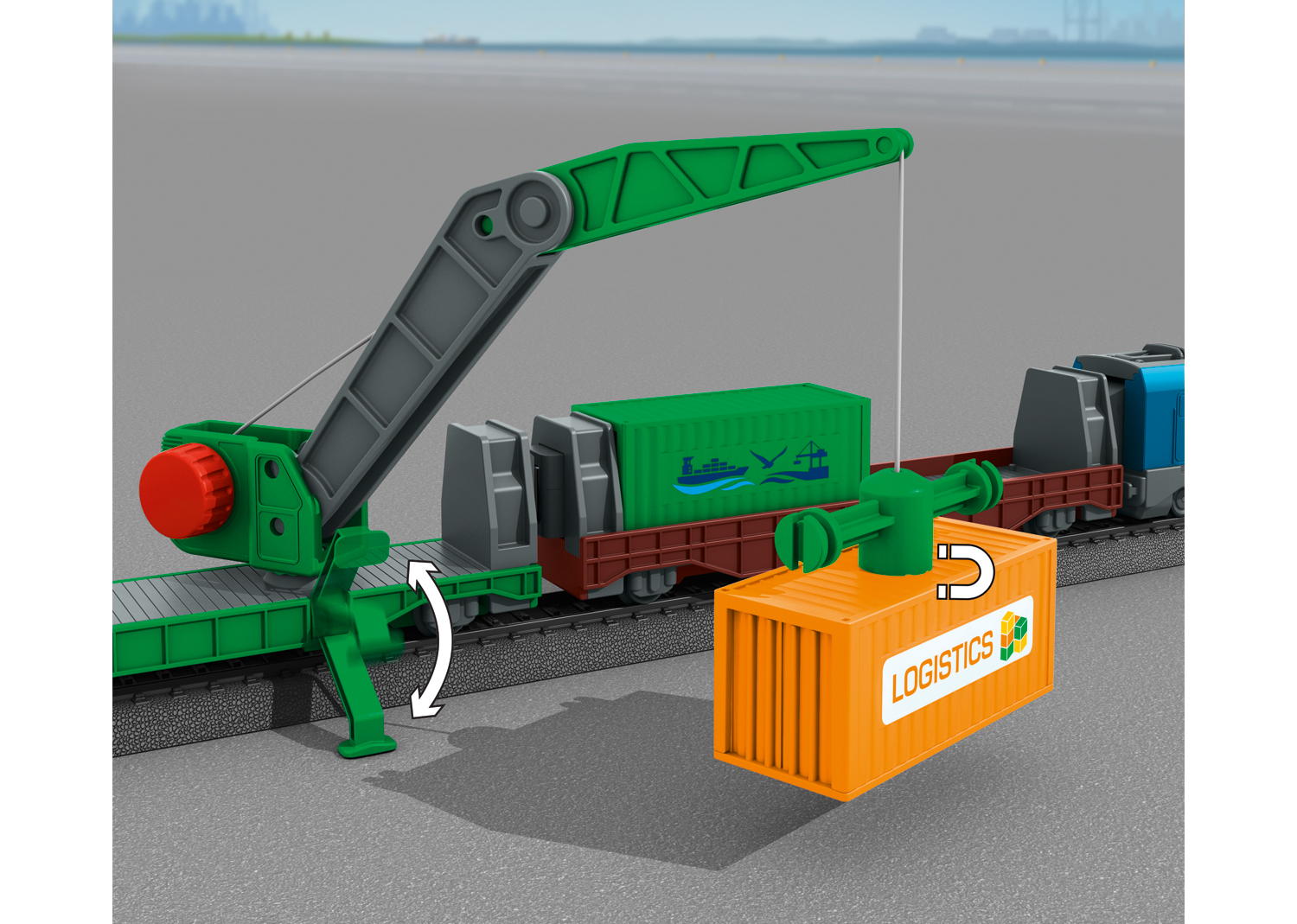 Wagonik zabawkowy z zielonym kontenerem podnoszonym przez dźwig, na szarej powierzchni.