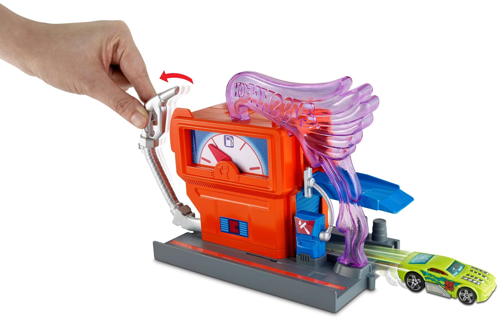Ręka obsługuje dyszę pompy paliwa na pomarańczowej stacji benzynowej Hot Wheels.