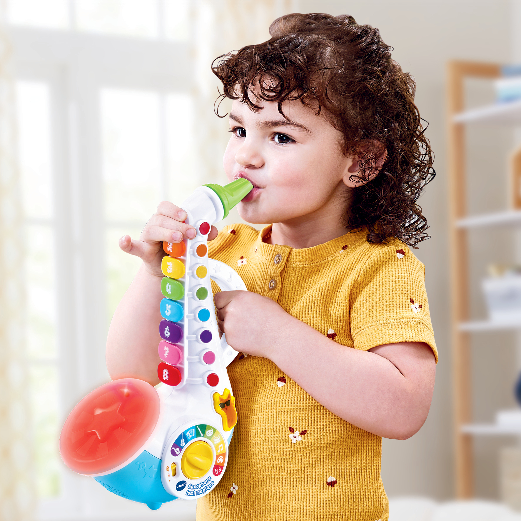 Una niña pequeña está tocando un saxofón de juguete. El saxofón es multicolor y tiene botones.