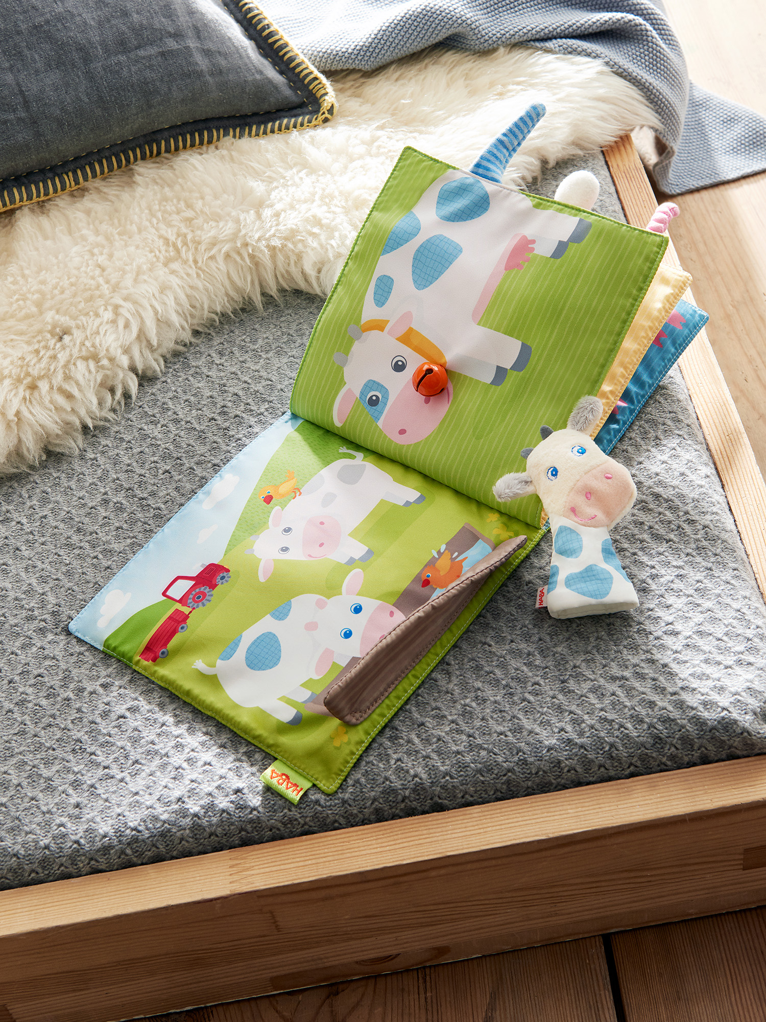 Książeczka dla dzieci z motywem krowy z zabawką krową na łóżku.