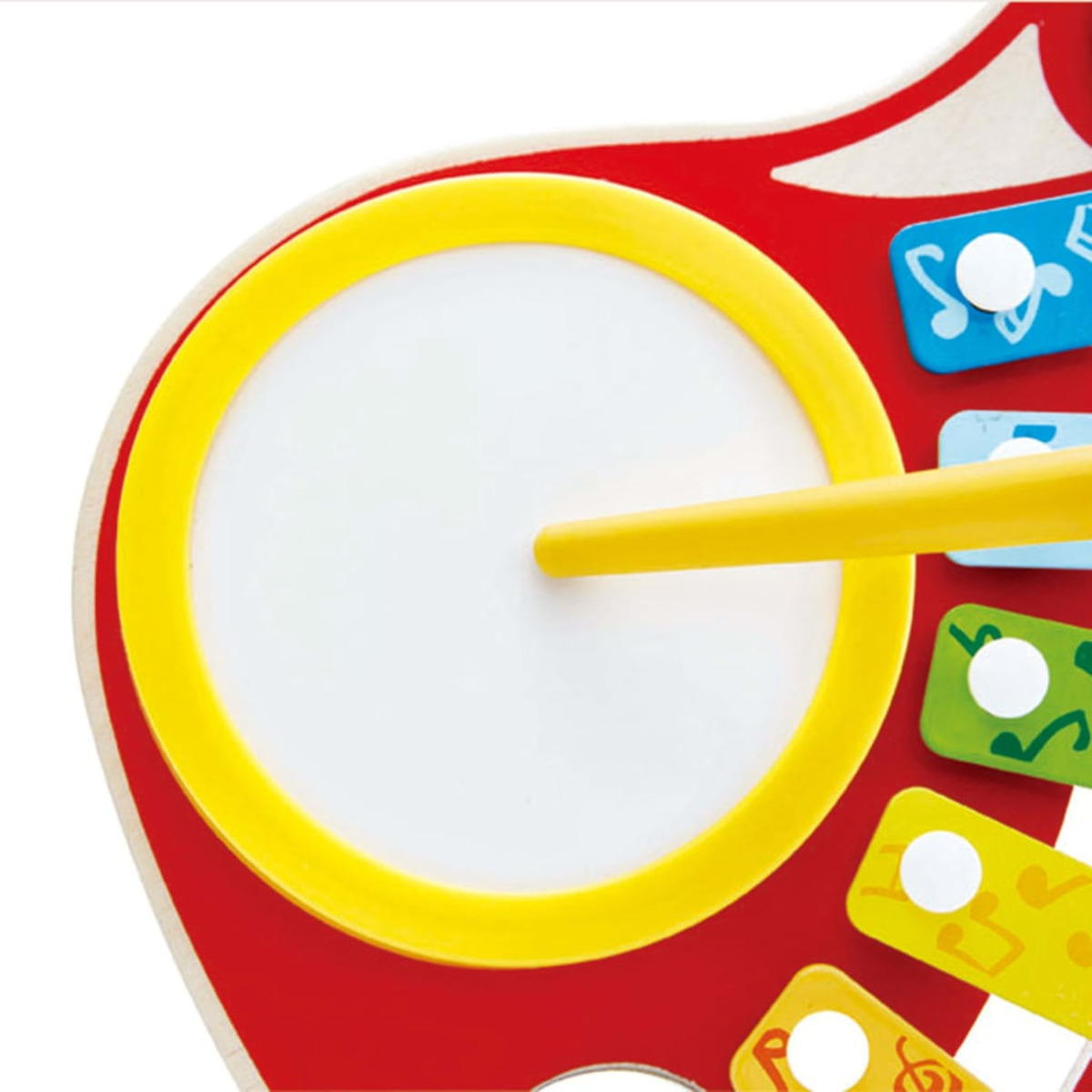 Spielzeuggitarre, roter Korpus, gelbe Trommel und bunte Tasten. Weißer Hintergrund.