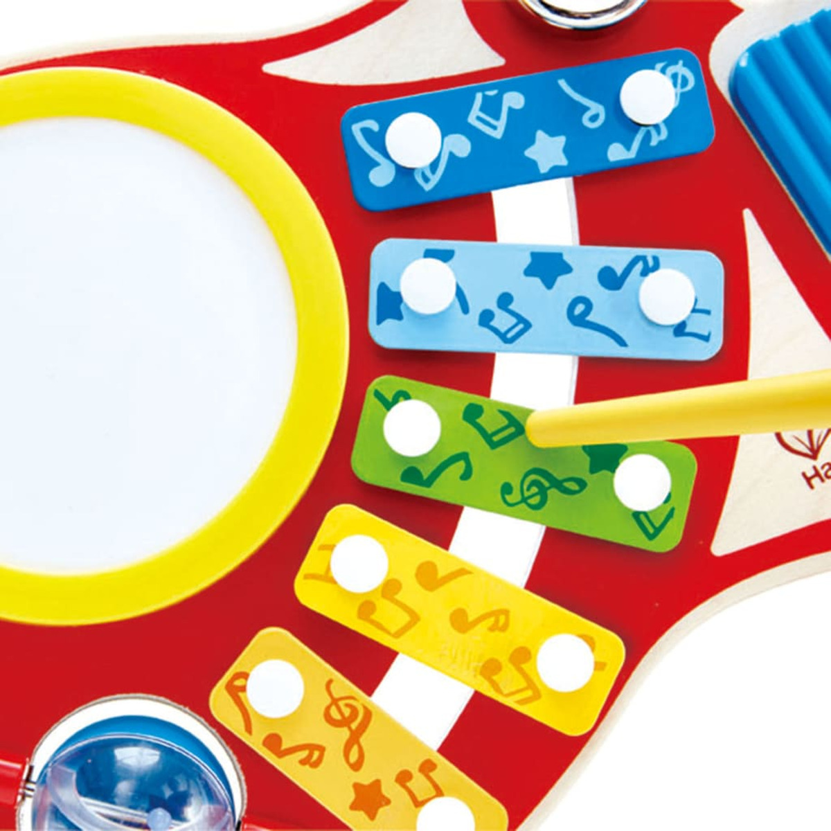 Eine Nahaufnahme eines roten Xylophon-Spielzeugs mit bunten Stäben und einer gelben Trommel, mit einem Schlägel.