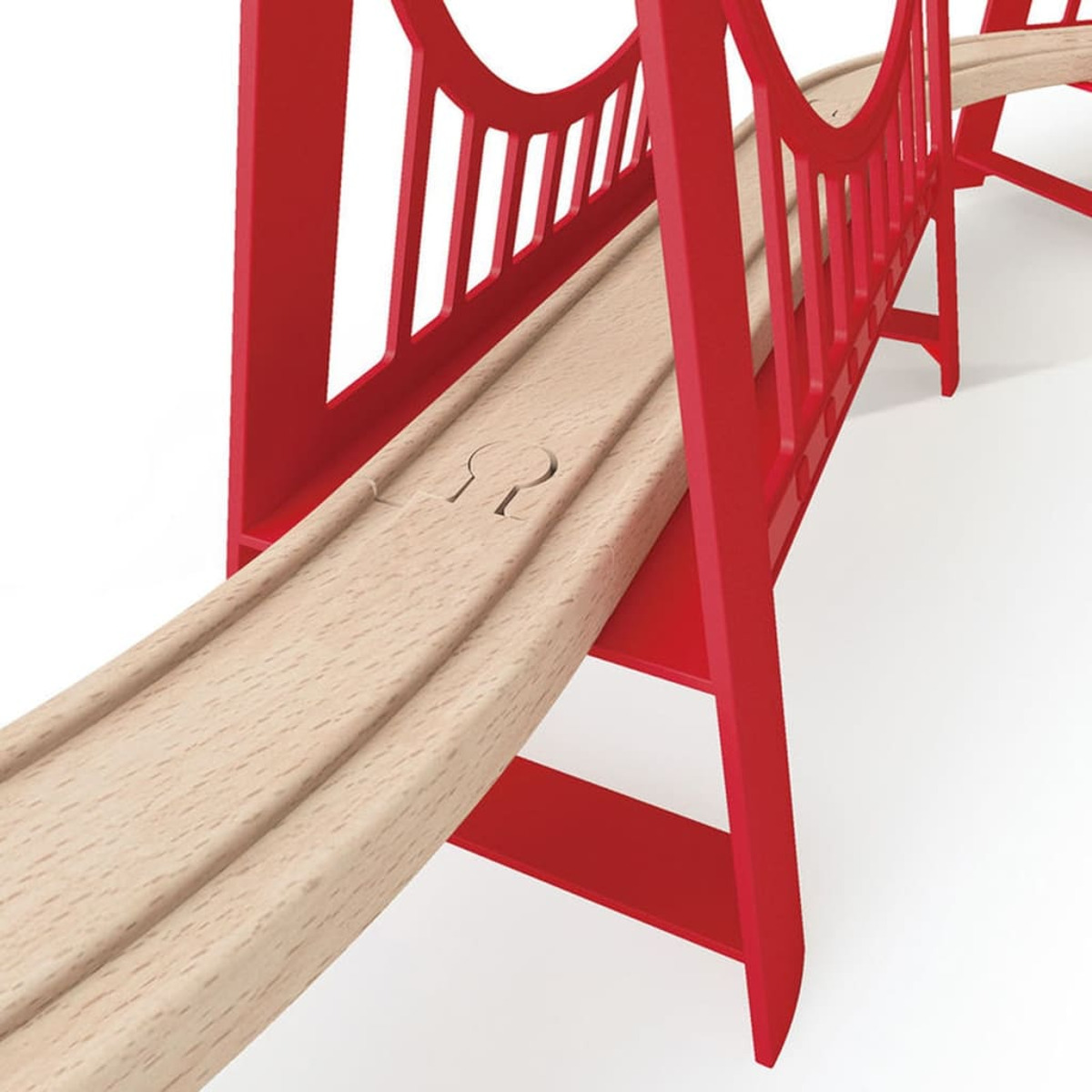 Zbliżenie czerwonej drewnianej zabawki mostu. Most stoi na jasnobrązowej drewnianej powierzchni.