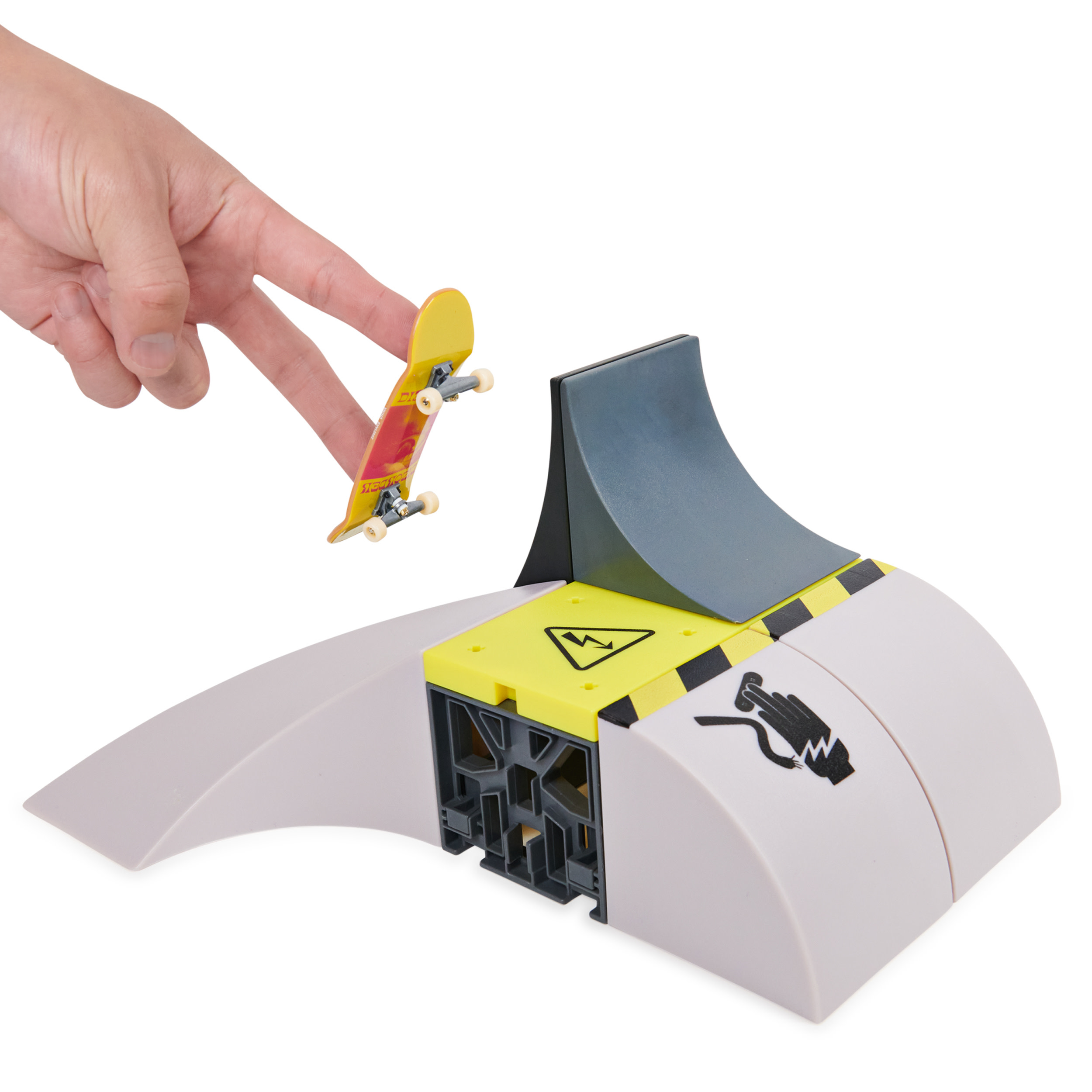 Ręka ma zamiar sprawić, by deskorolka zeskoczyła z rampy skateparku.