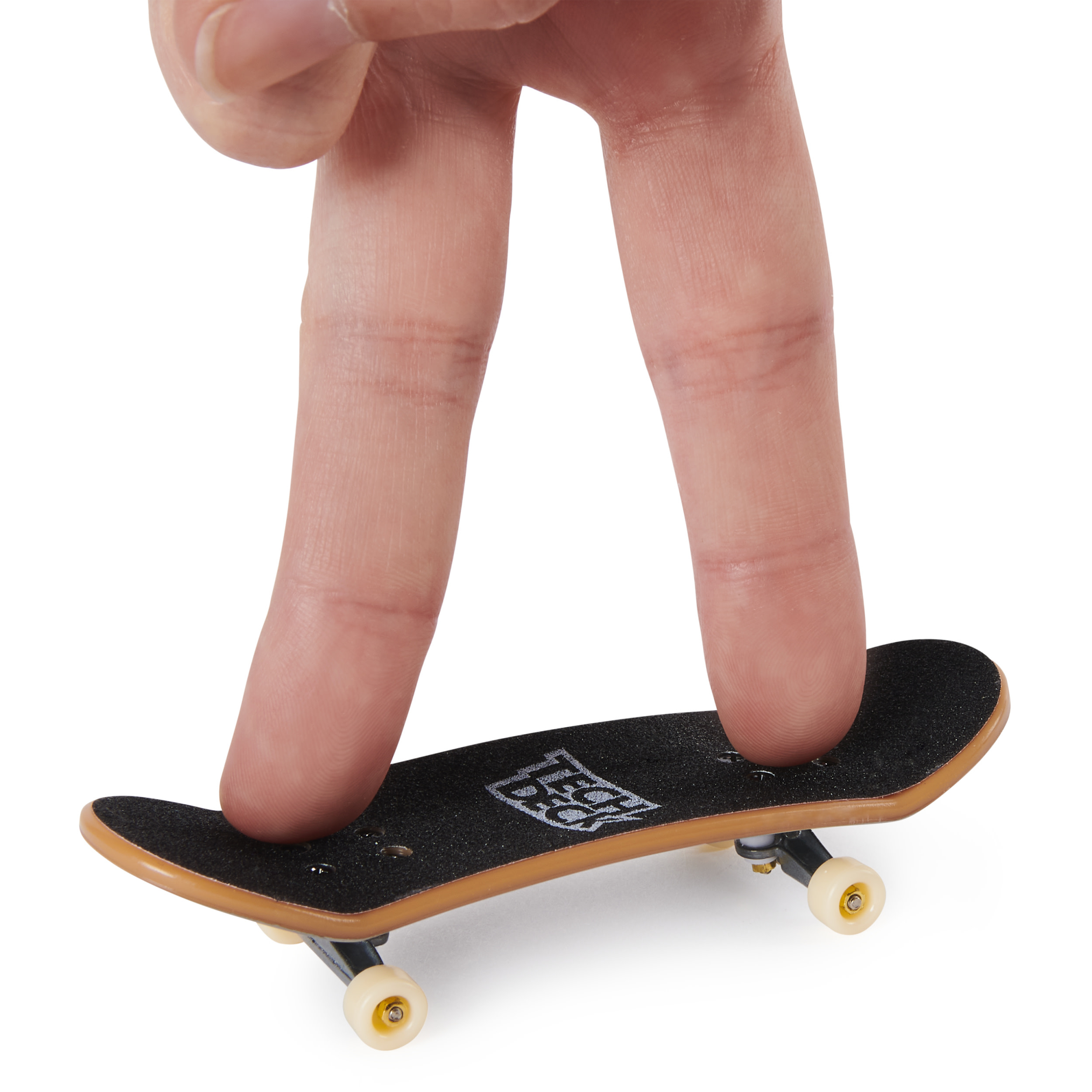 Palec trzyma miniaturową deskorolkę Tech Deck na białym tle.