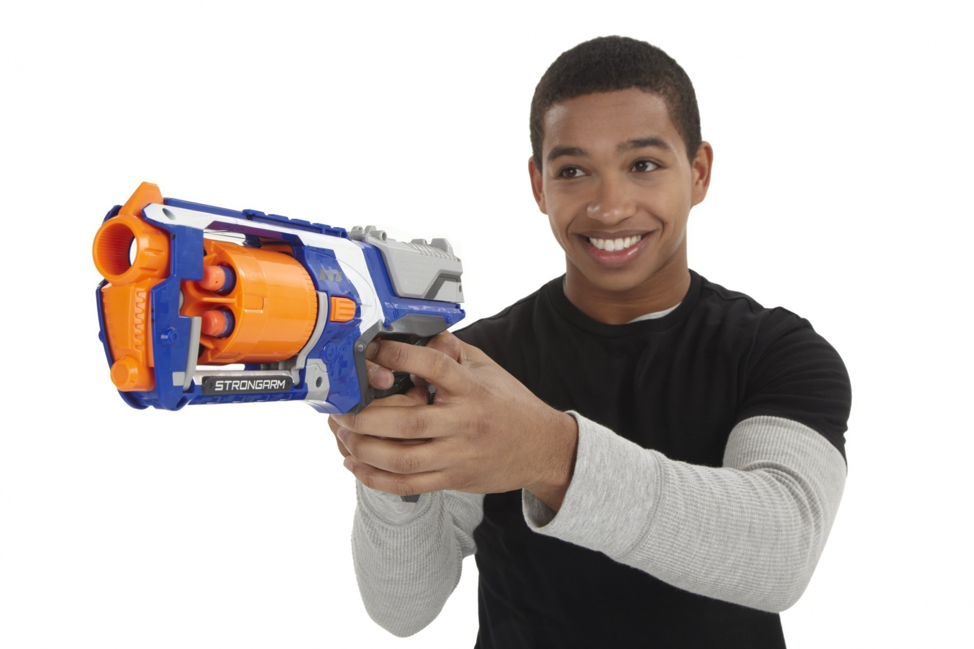 Un giovane sorridente, che tiene in mano una pistola giocattolo blu e arancione.