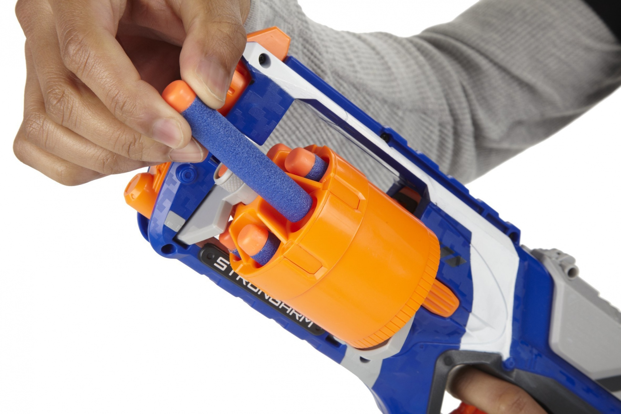 Una mano che carica un dardo blu in una pistola Nerf arancione e blu, primo piano.