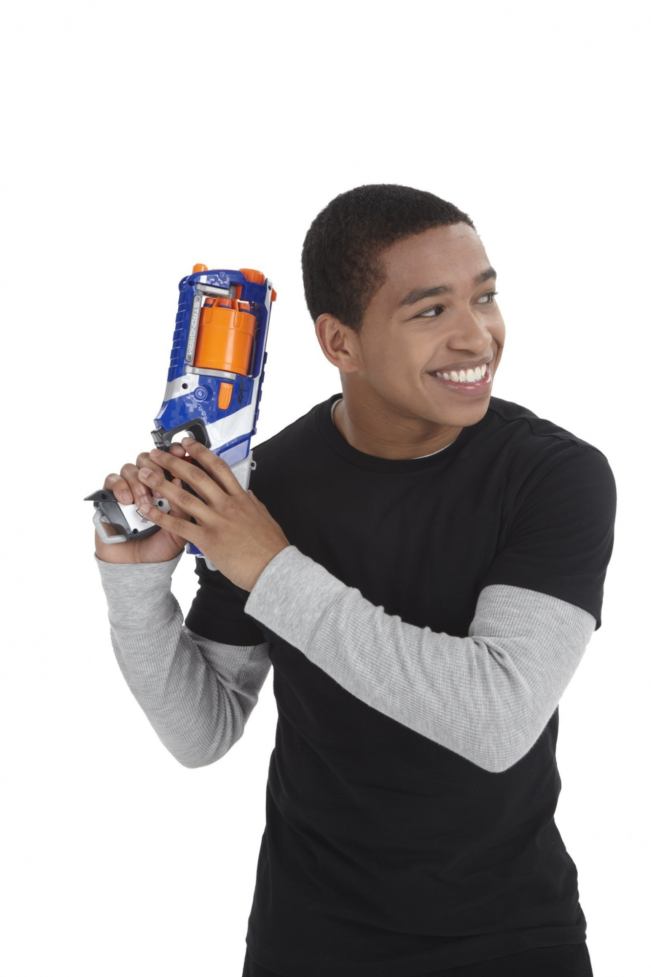 Un giovane che tiene in mano una pistola Nerf blu e arancione. Sta sorridendo e guardando di lato.